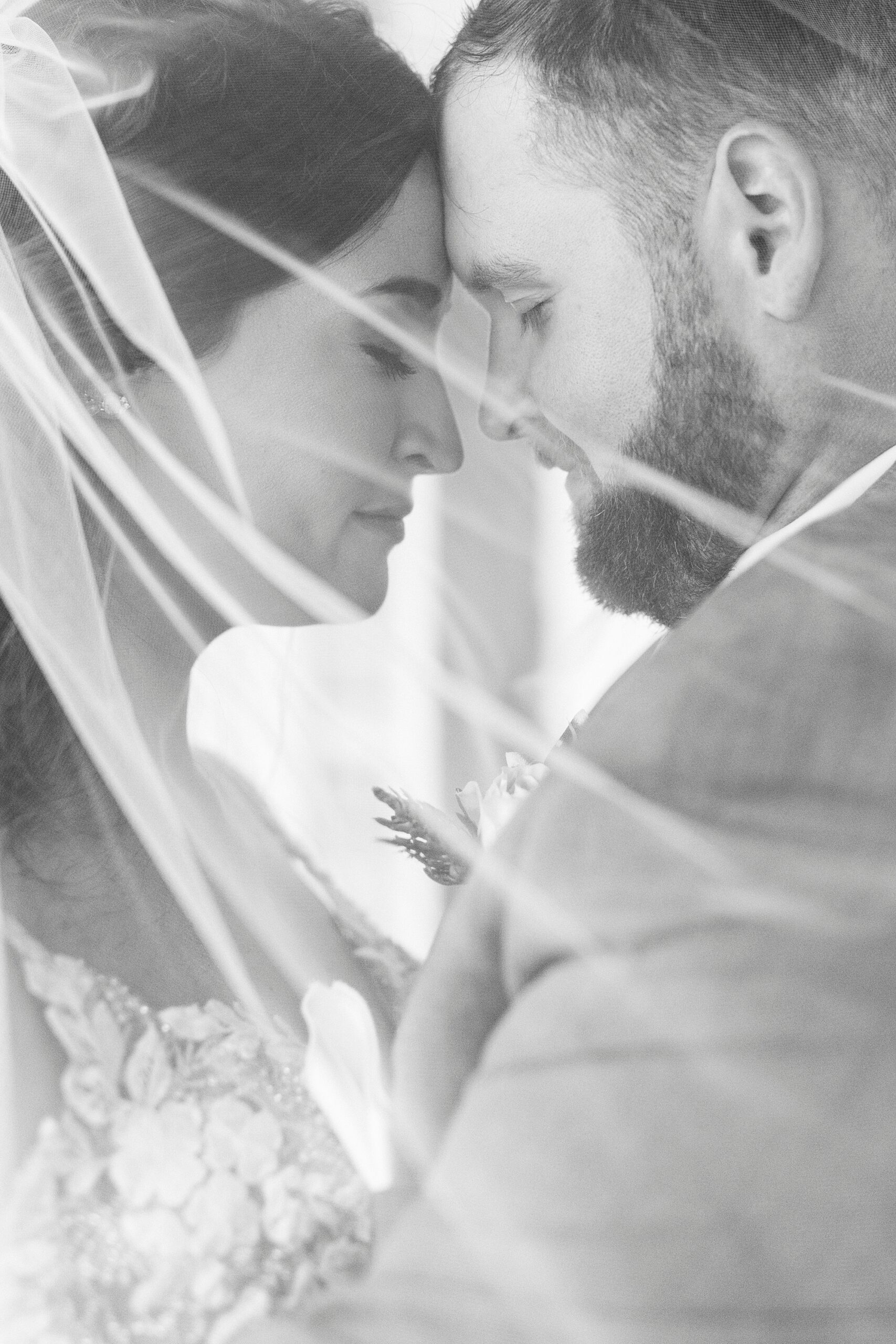 bride and groom hug under bride's veil