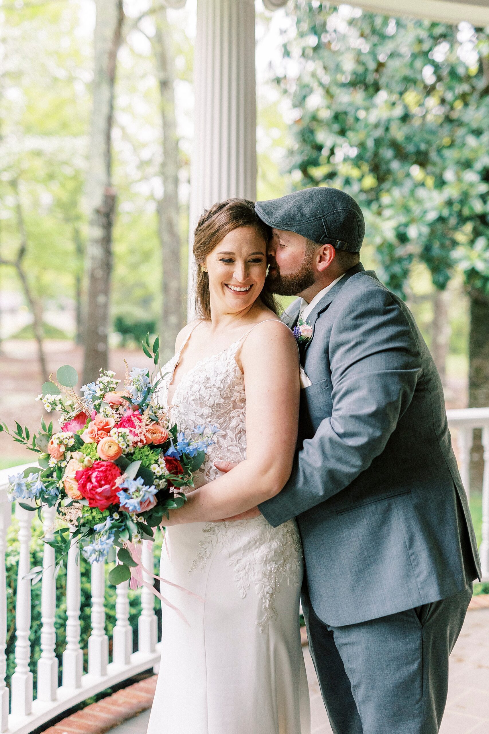 groom hugs bride from behind kissing her cheek at The Saratoga Springs
