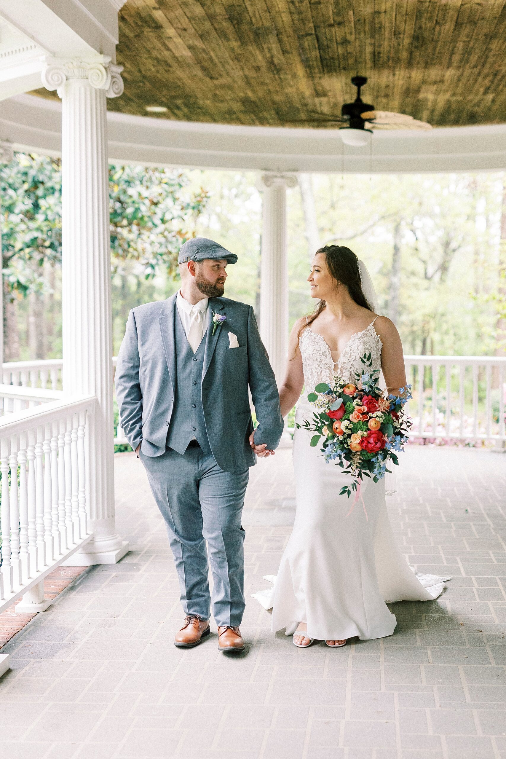 bride and groom hold hands walking on porch at The Saratoga Springs