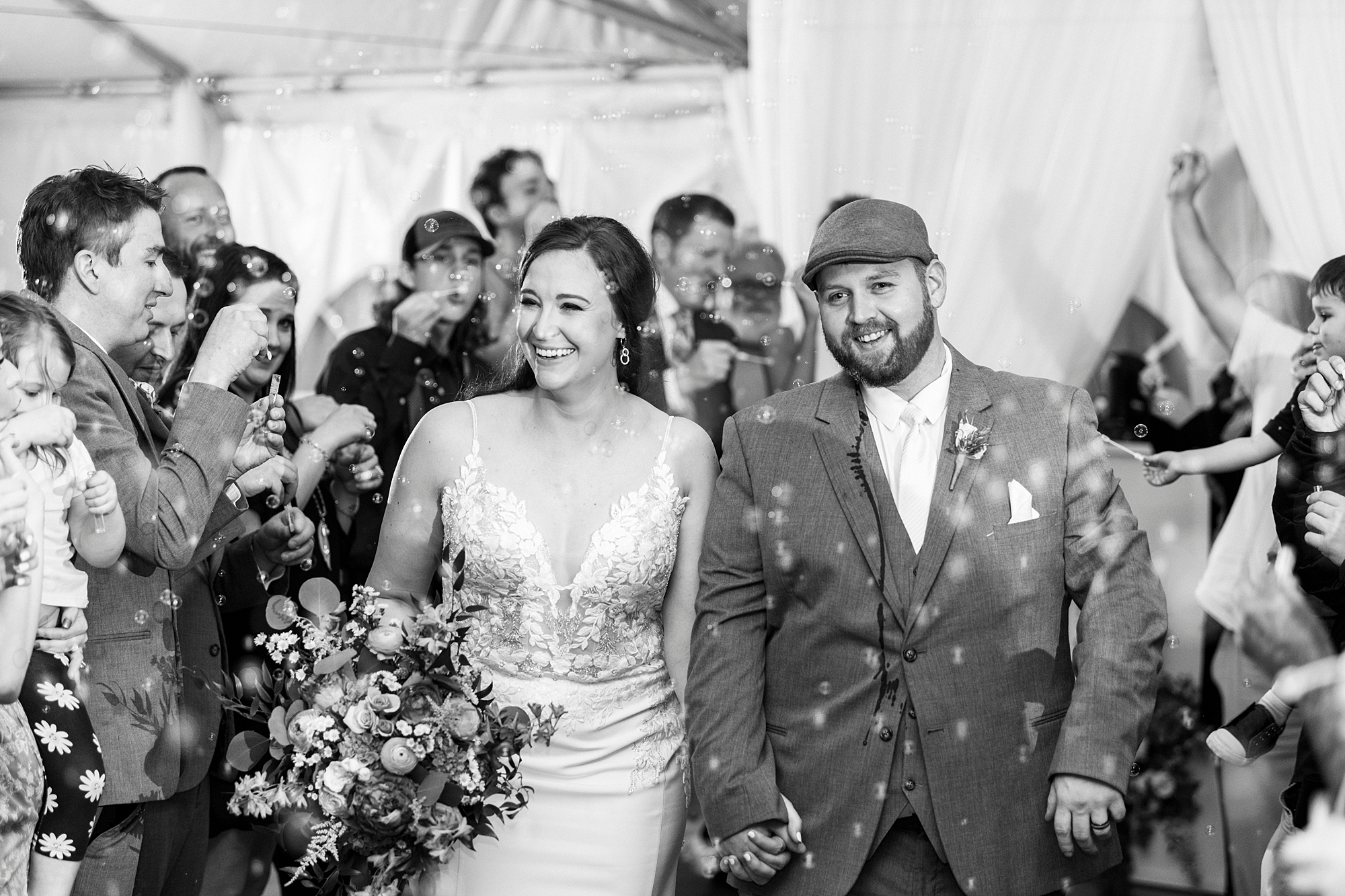bride and groom hold hands during bubble exit from Charlotte NC wedding reception 