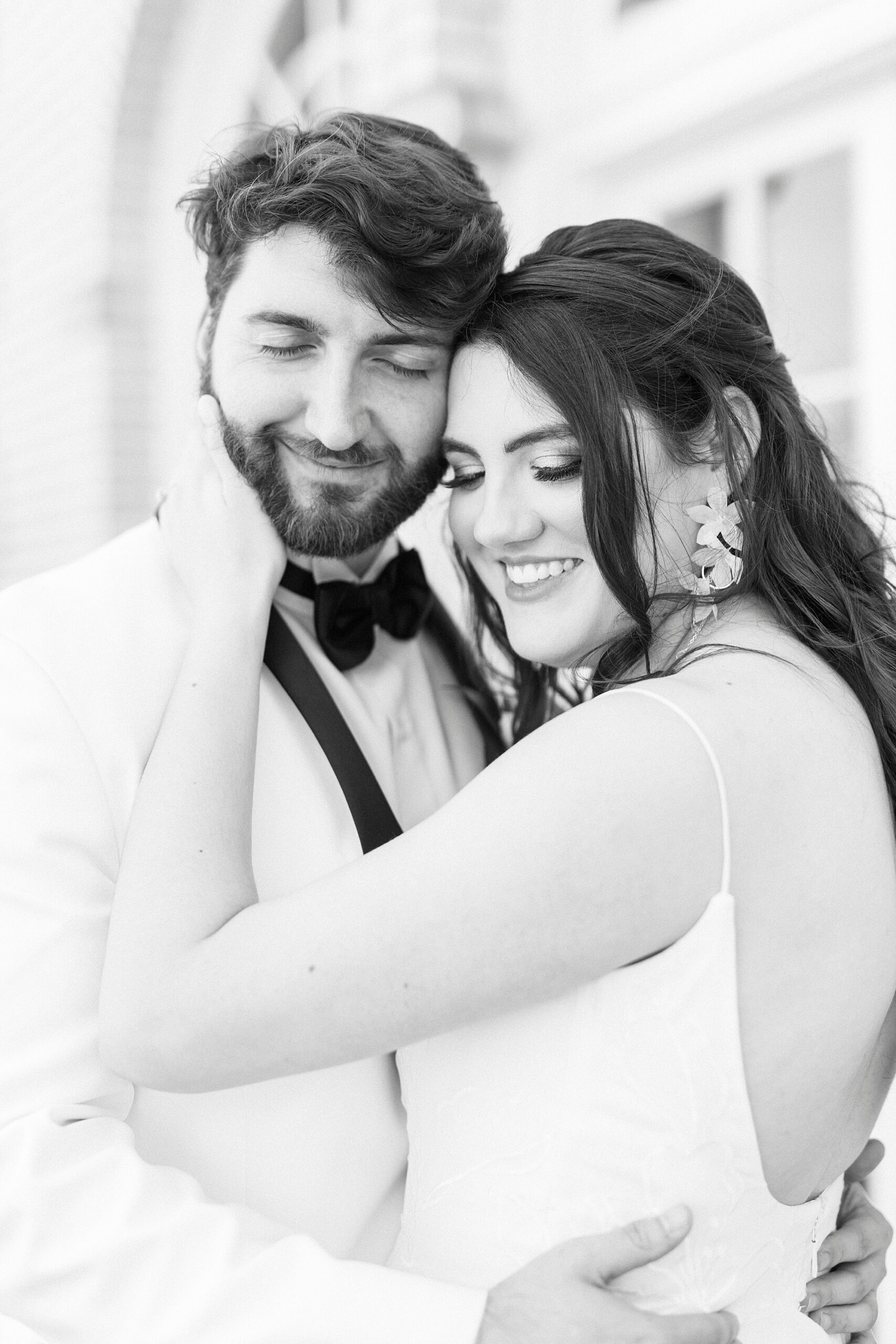 bride hugs groom holding his cheek during spring wedding day 
