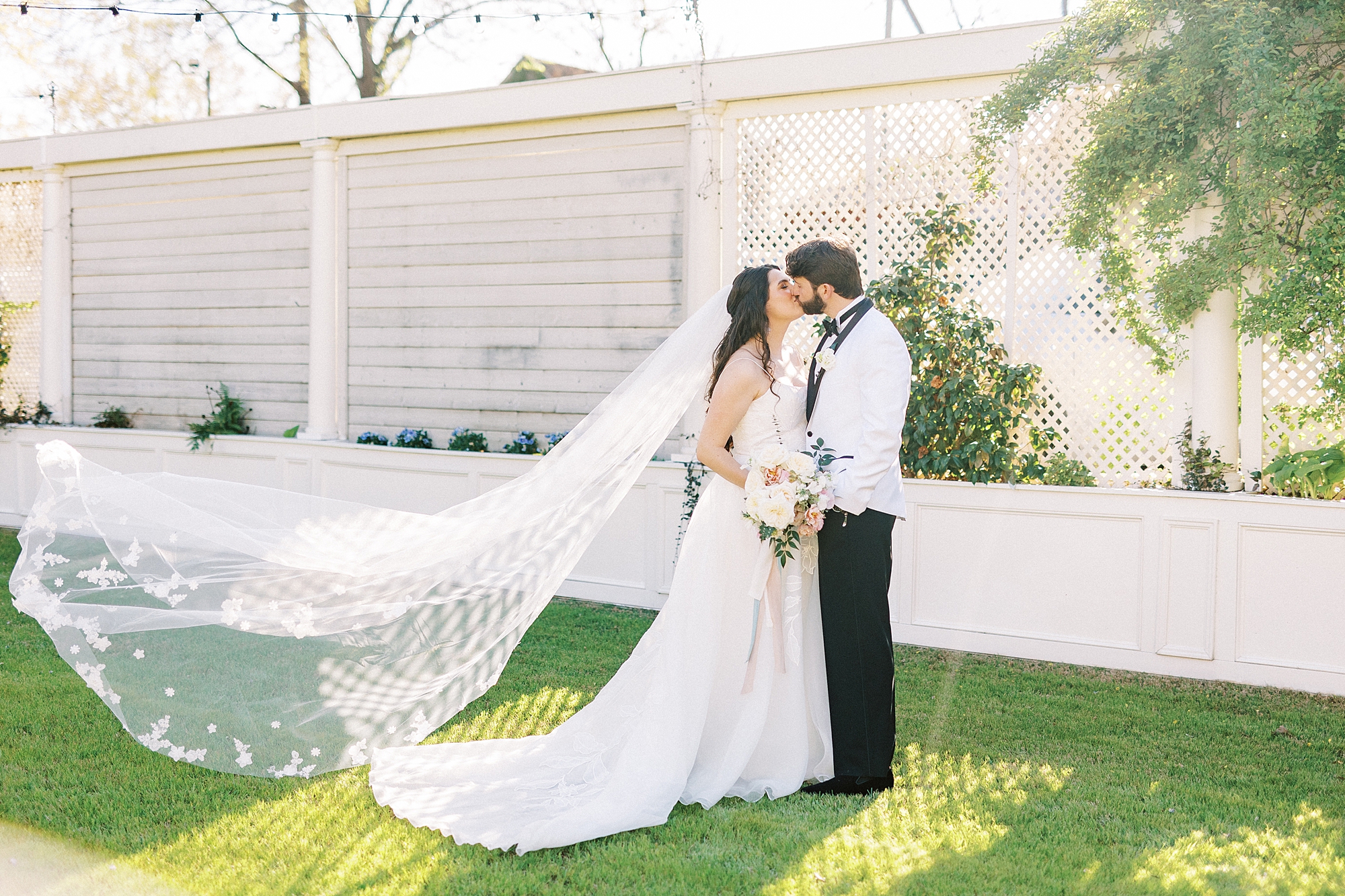 bride and groom kiss with bride's veil floating in courtyard at Separk Mansion
