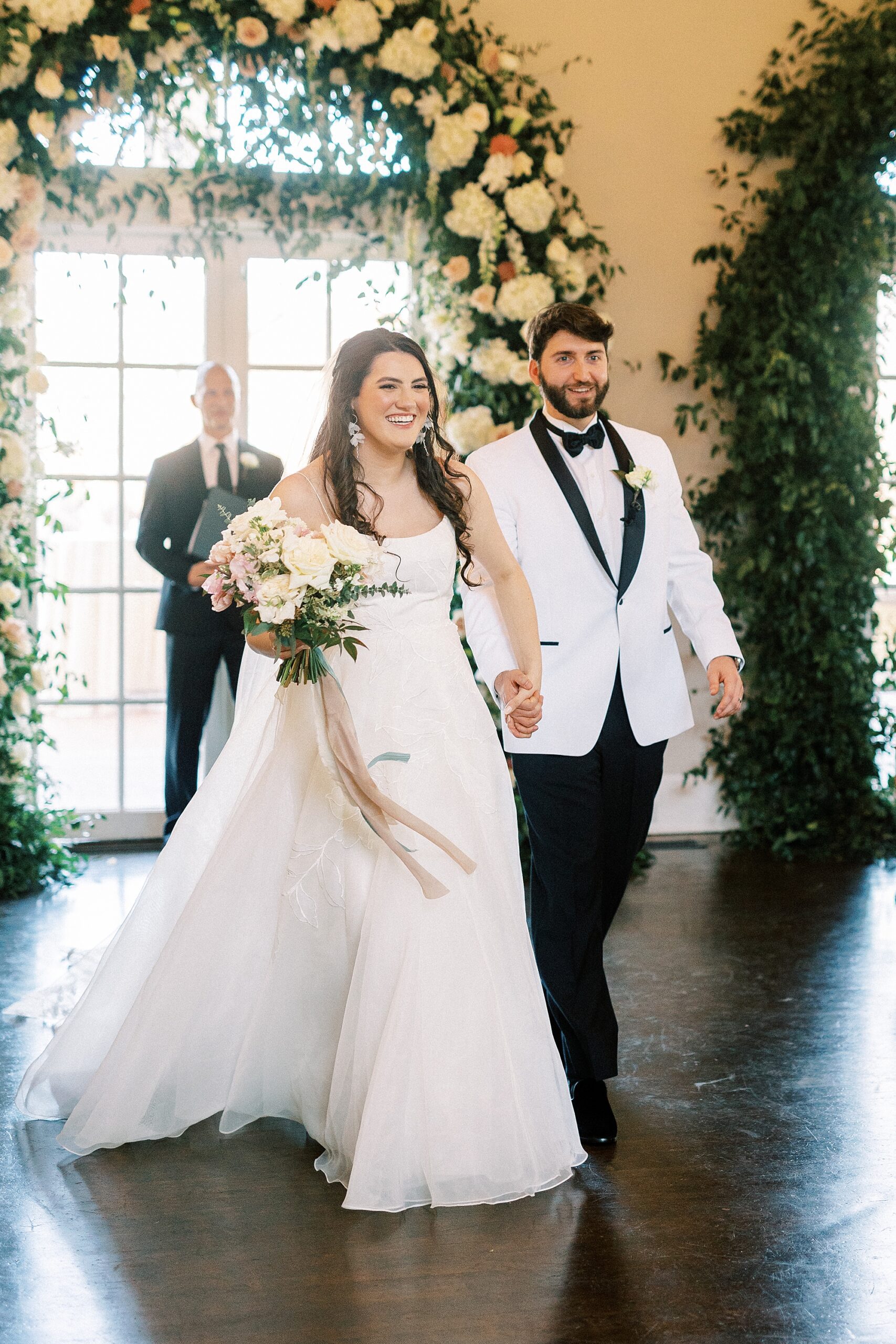 bride and groom hold hands leaving wedding ceremony at Separk Mansion