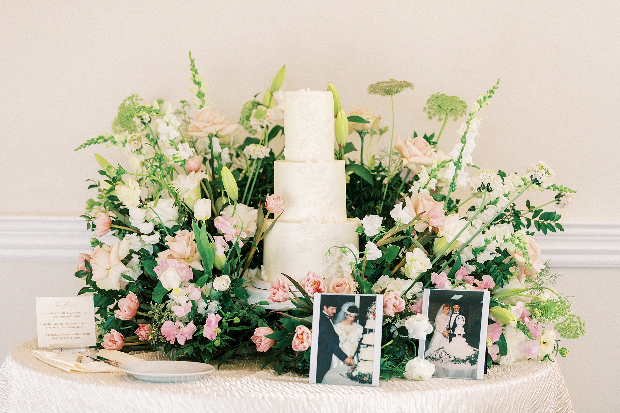 wedding cake nestled between pink and white flowers on table at Separk Mansion