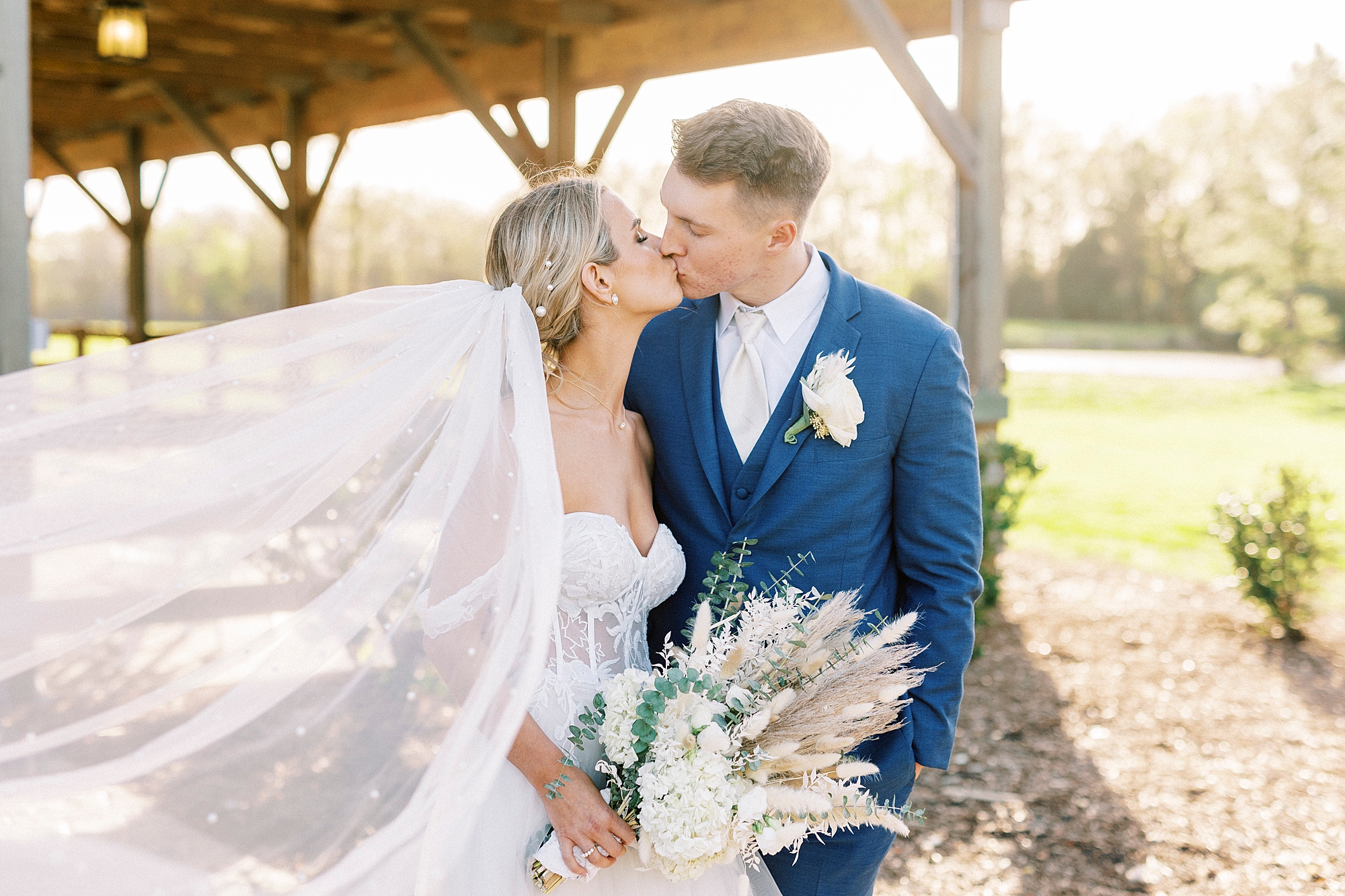 newlyweds kiss with veil floating in the wind