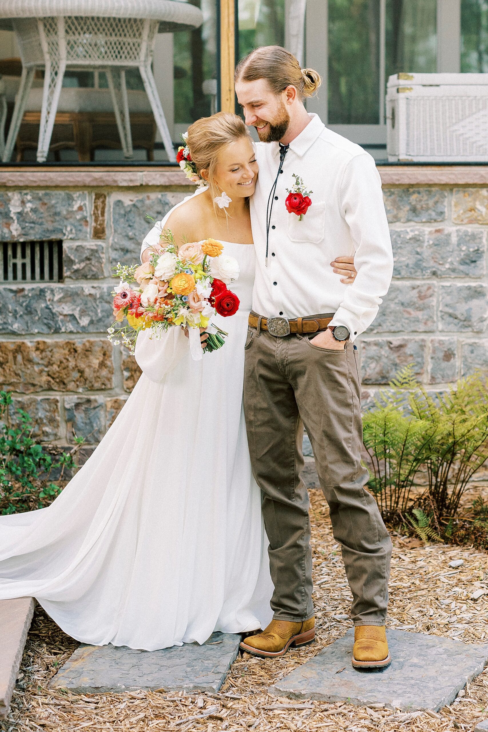 groom hugs bride to his side and kisses her forehead during first look