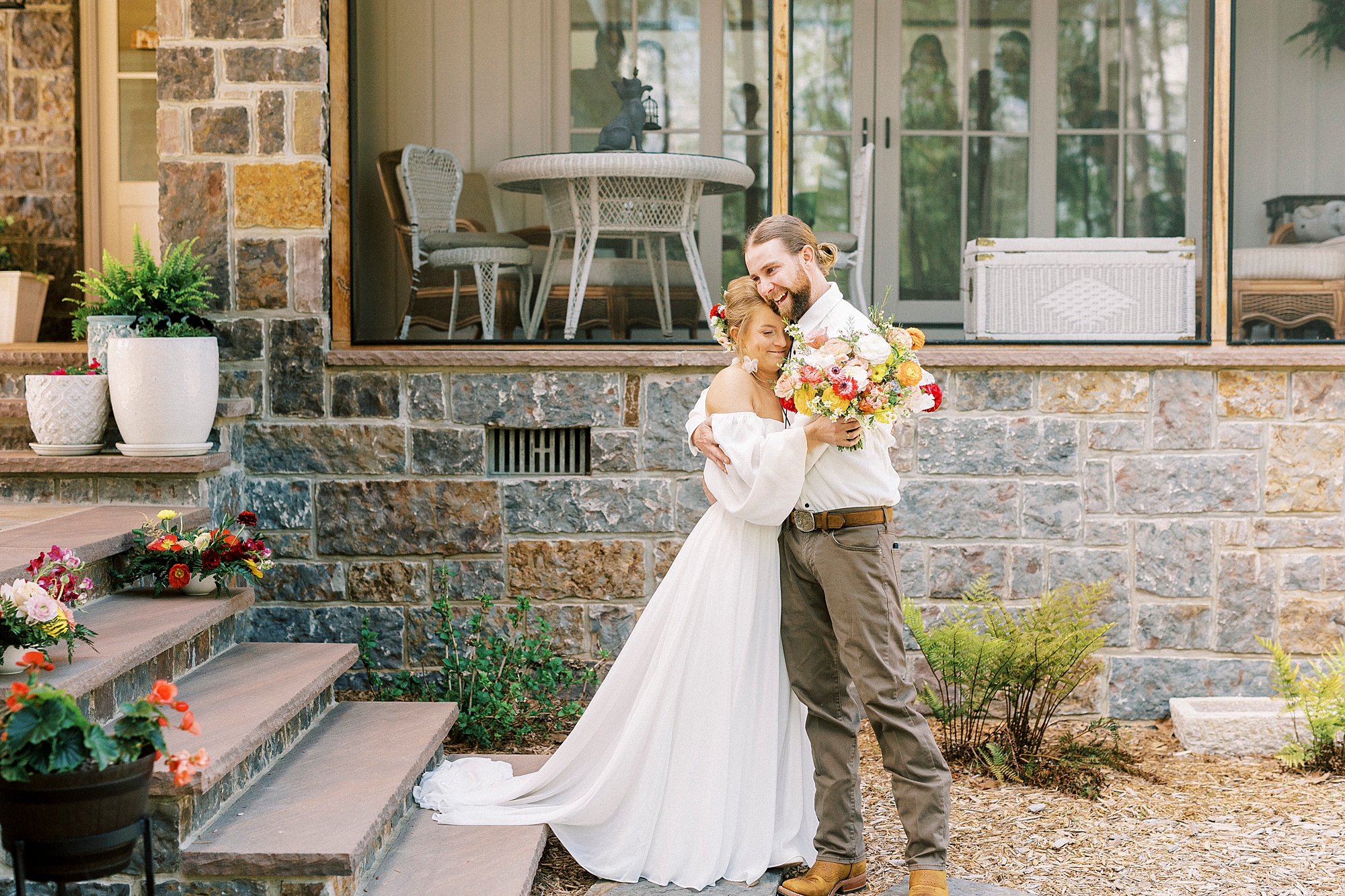 couple hugs by stone front steps of Richfield NC home