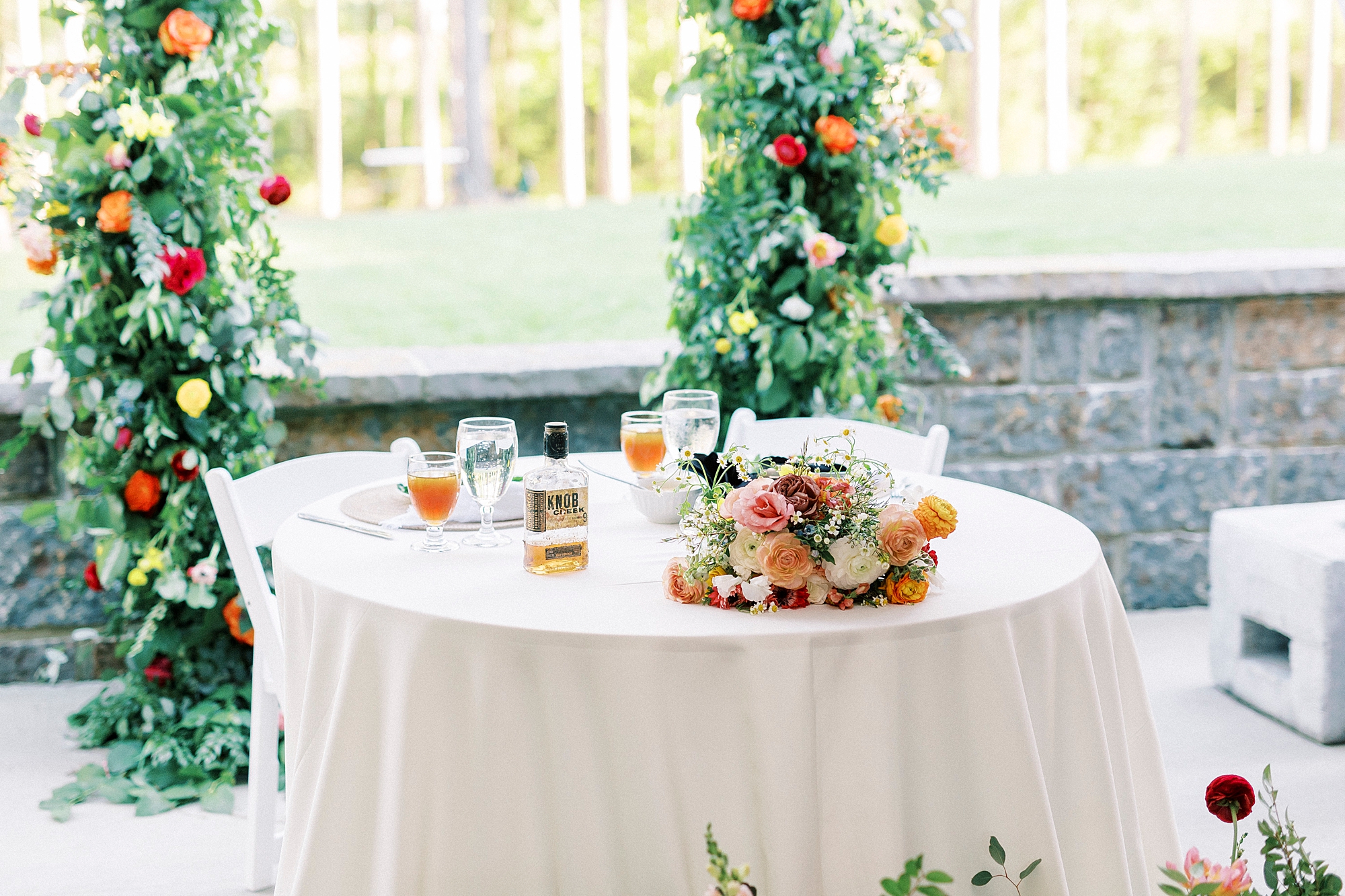 bourbon from yard sits on head table during wedding reception on lawn in Richfield NC