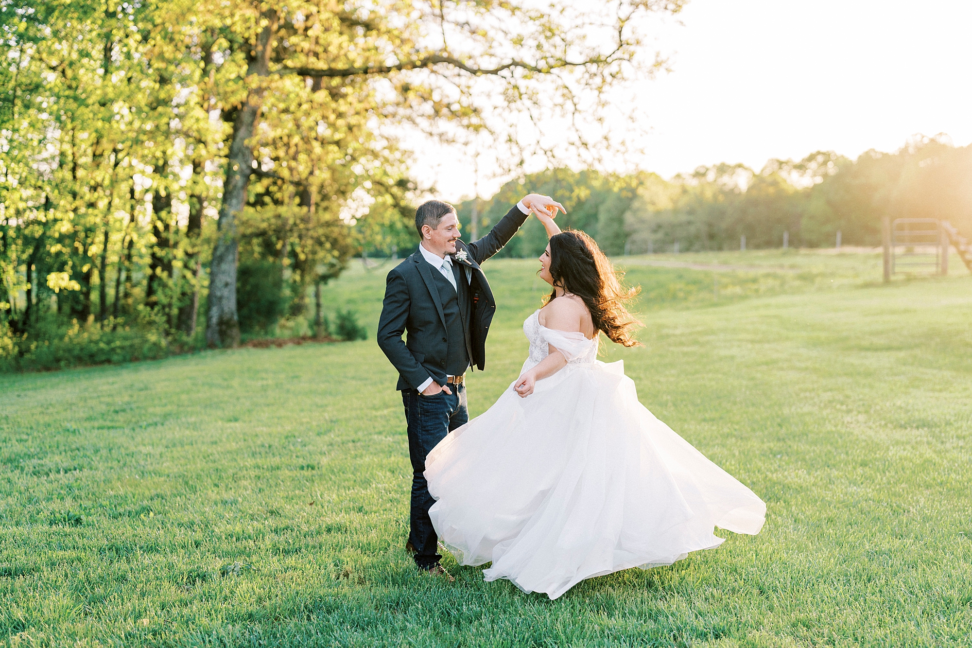 groom twirls bride on lawn at Danner Farms