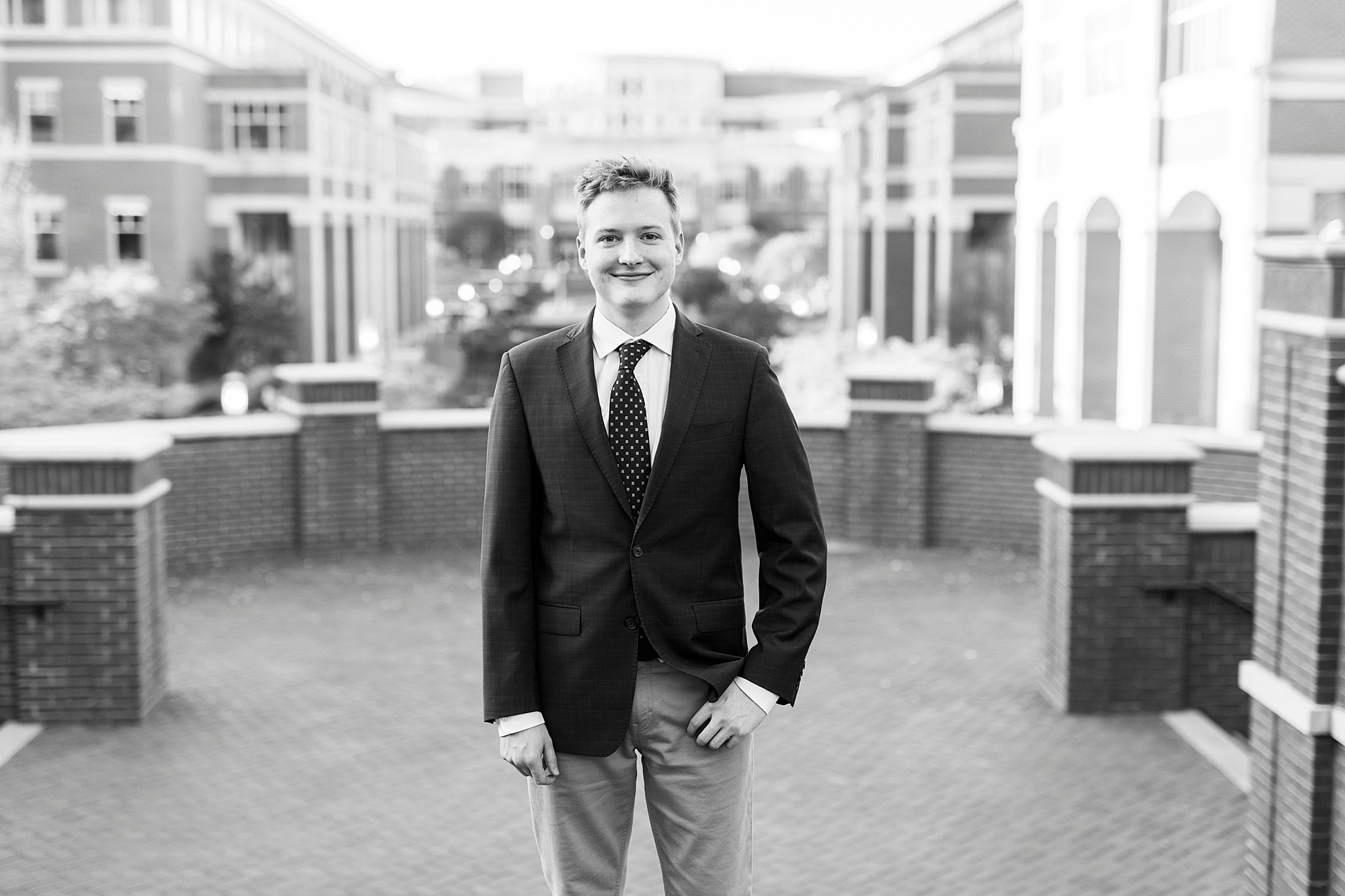 senior poses with hand on pocket on quad at UNC Charlotte
