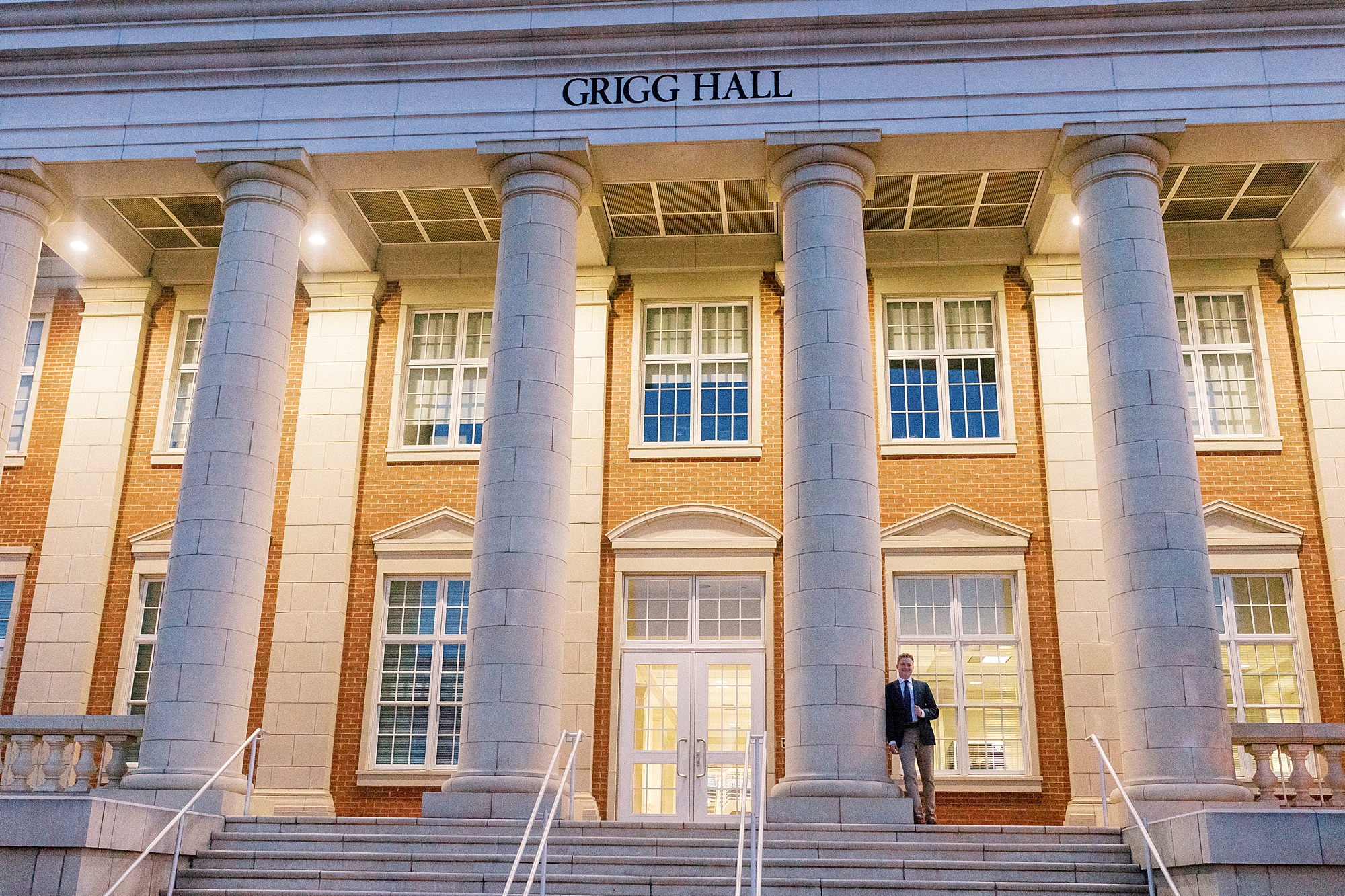 senior leans against marble column outside building at UNC Charlotte
