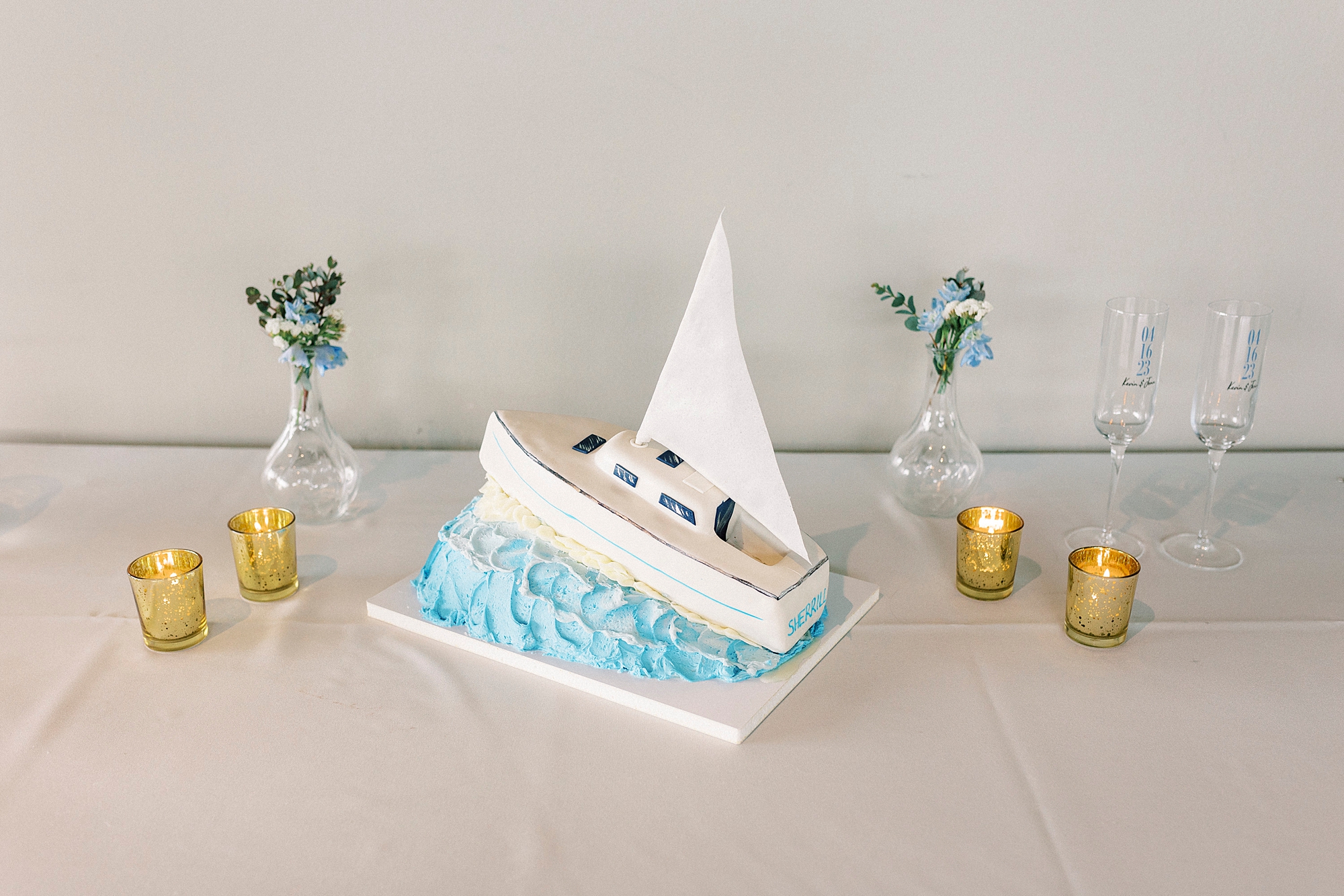 wedding cake in shape of boat between gold candles
