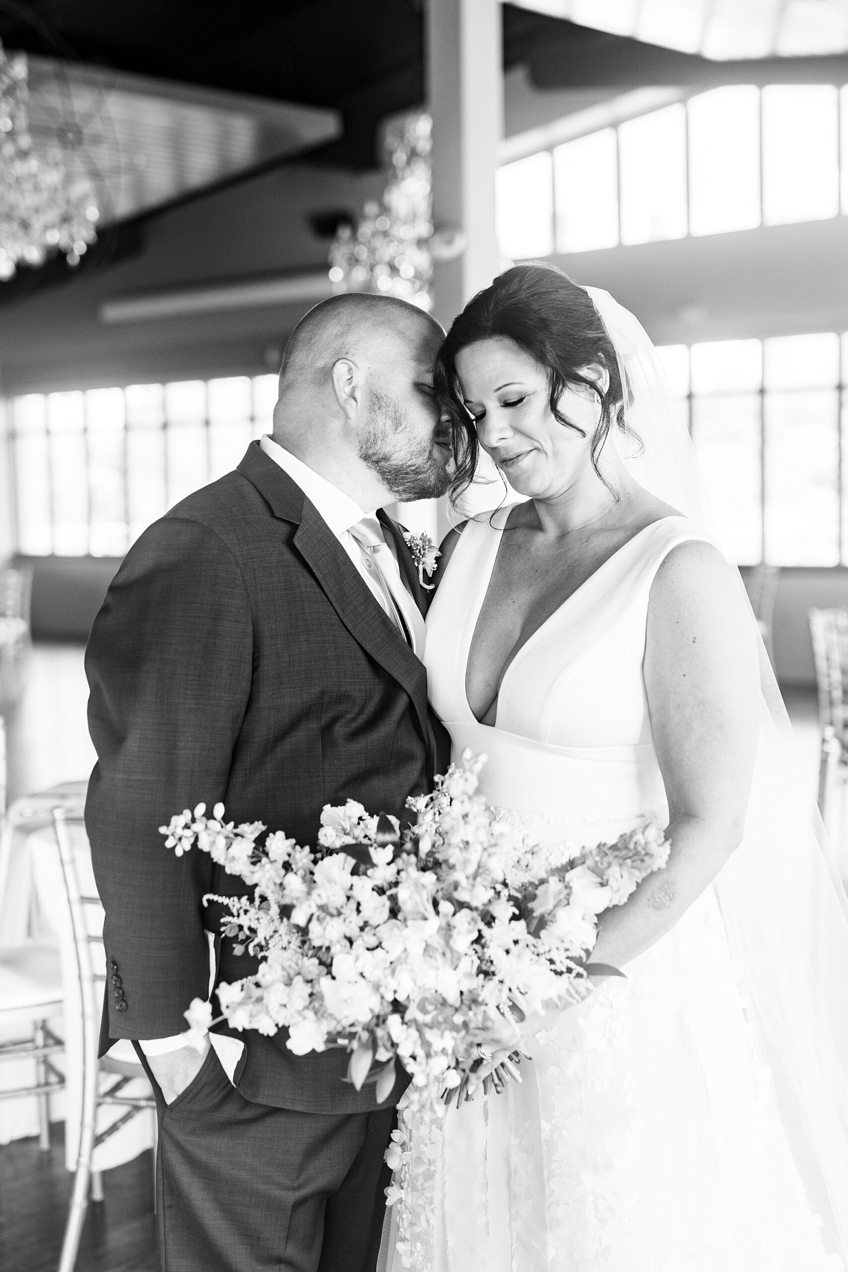 groom leans to kiss bride's chin