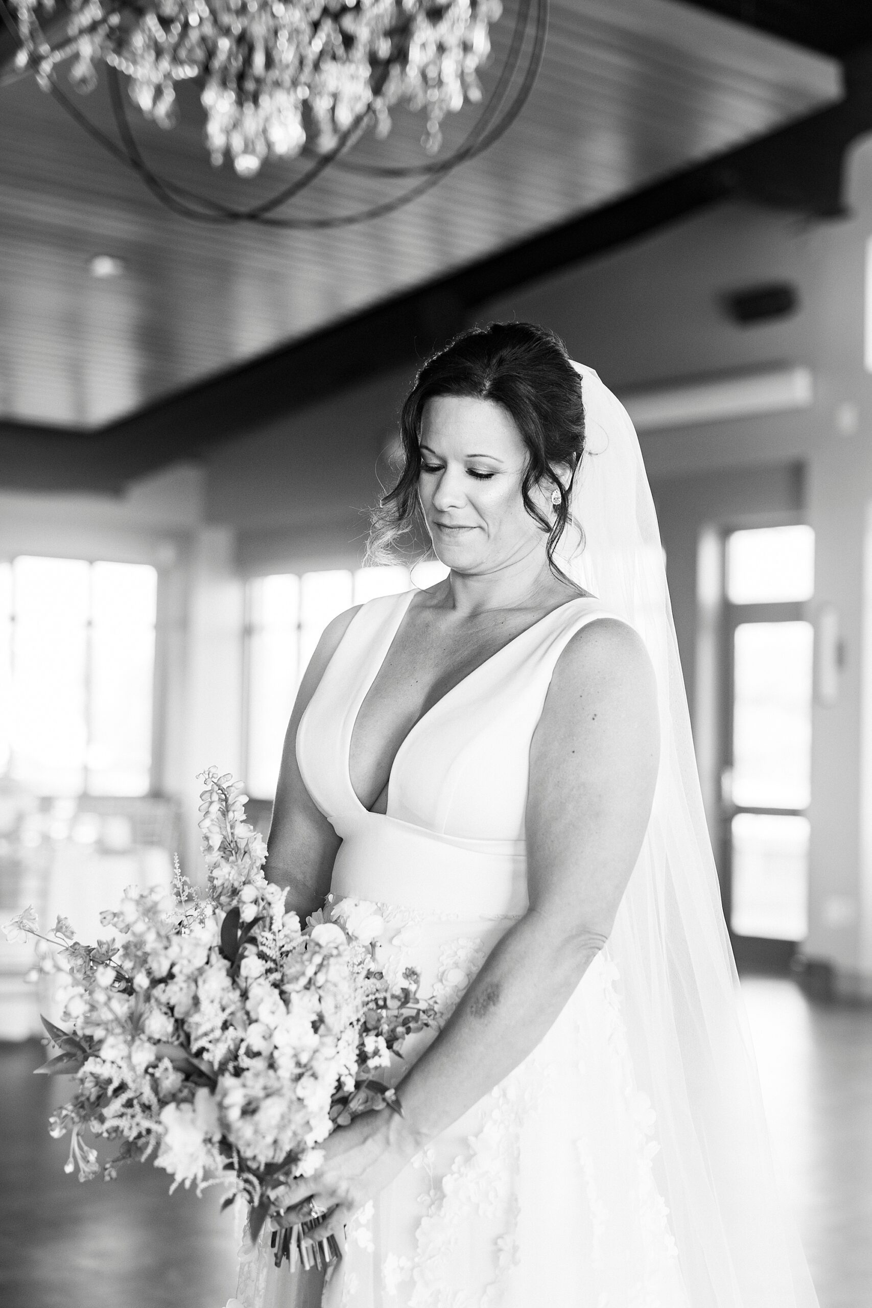 bride looks down at bouquet inside the Terrace at Cedar Hill