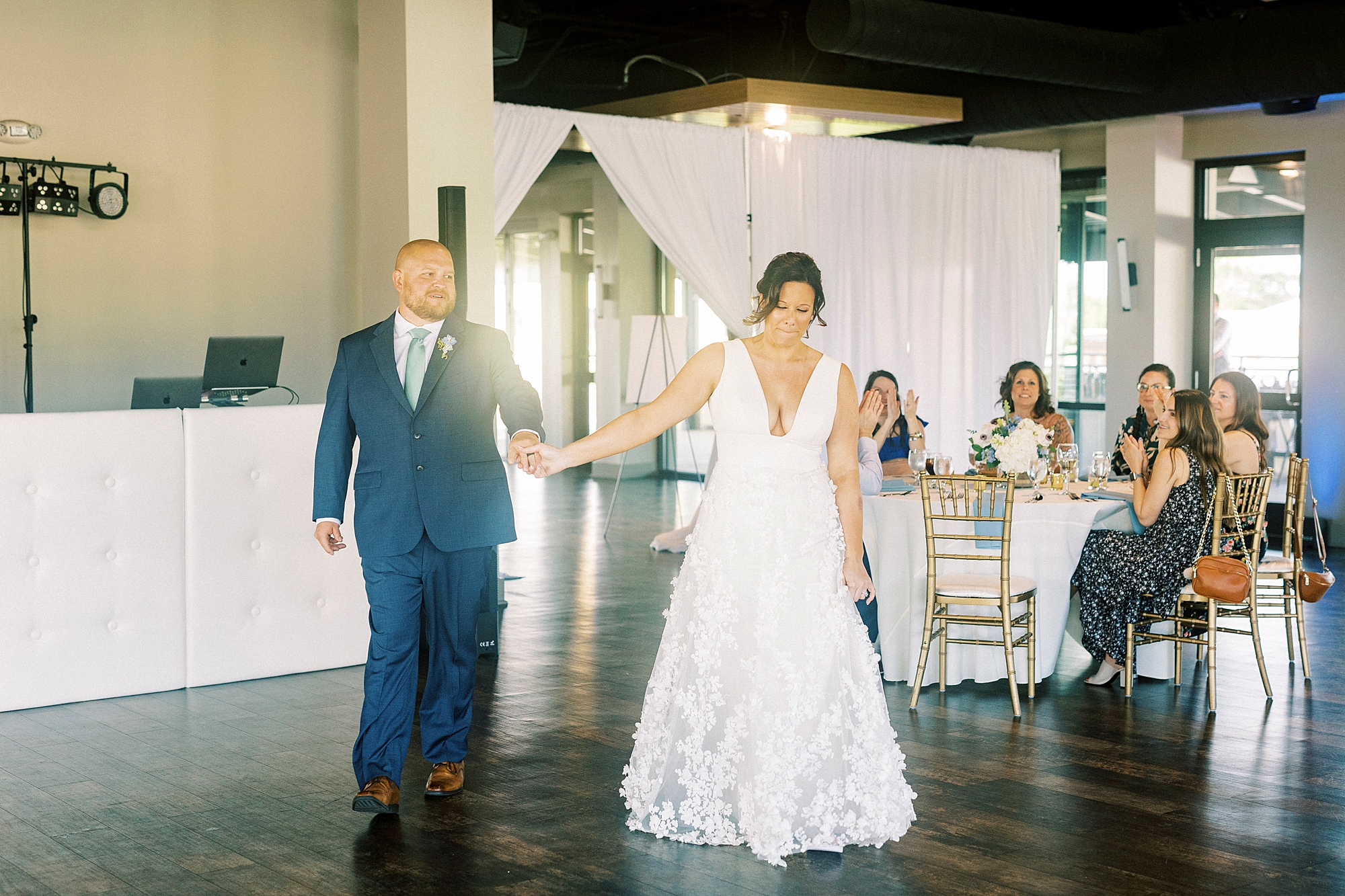 bride and groom hold hands walking into wedding reception at the Terrace at Cedar Hill