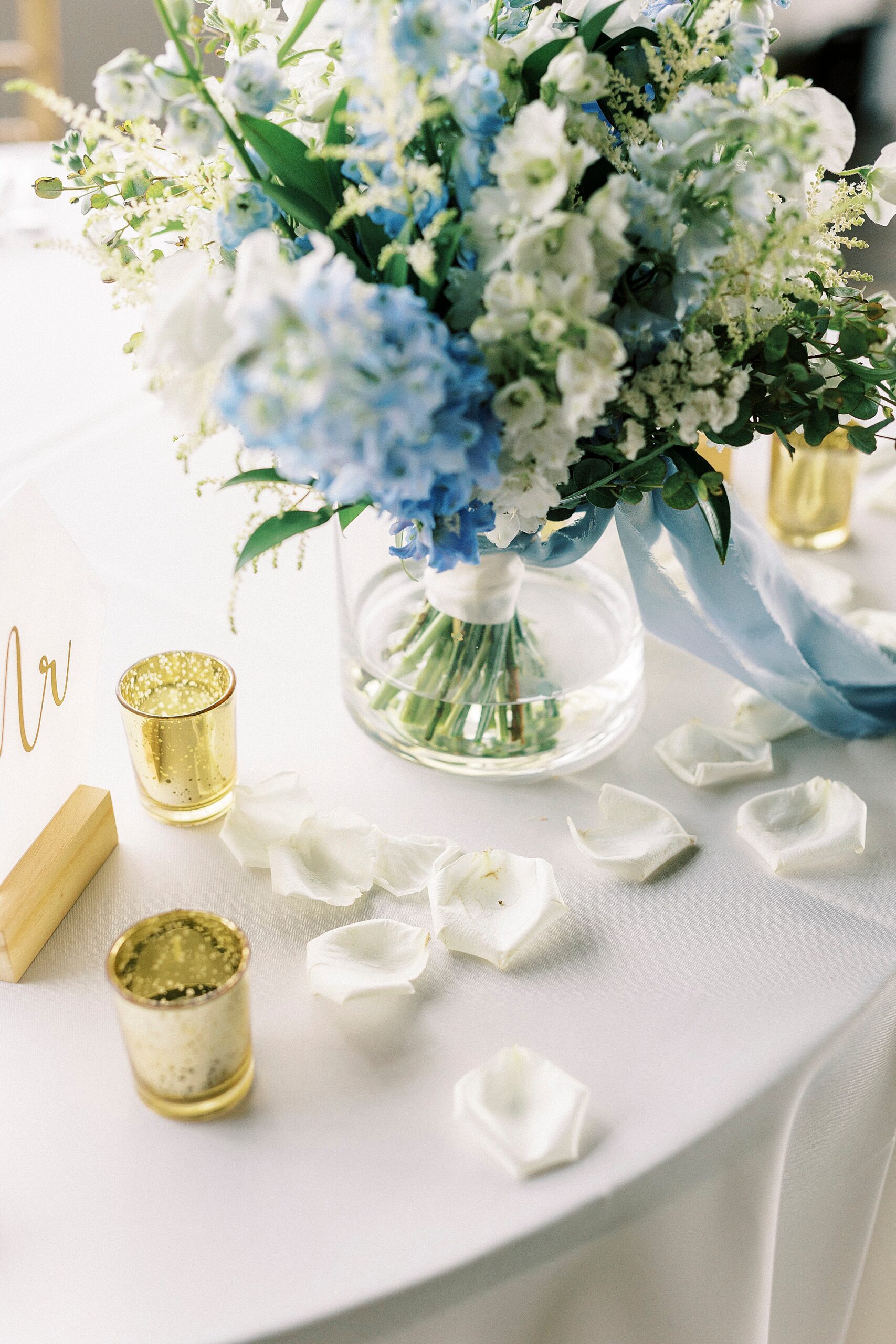white roses petals lay under floral arrangement at the Terrace at Cedar Hill