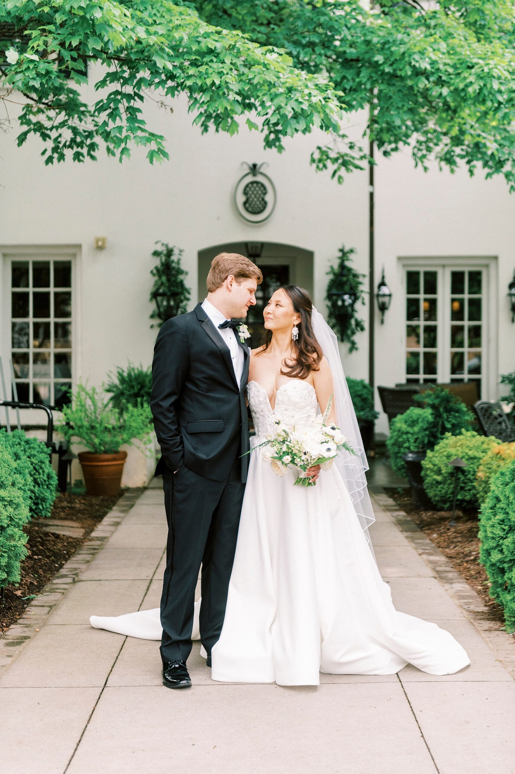 bride and groom smile at each other outside The Spring House