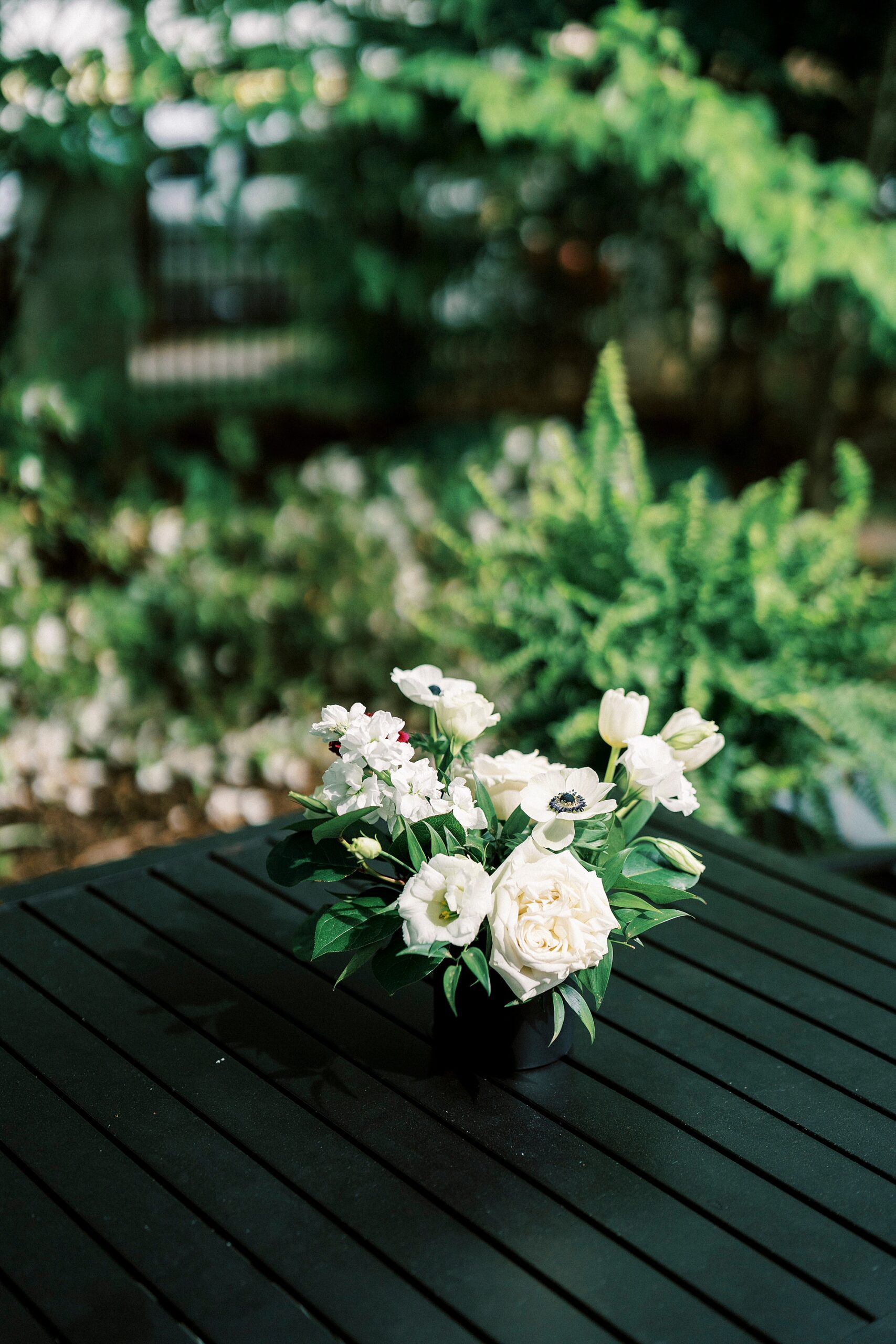 small centerpiece of ivory roses on black table at The Spring House
