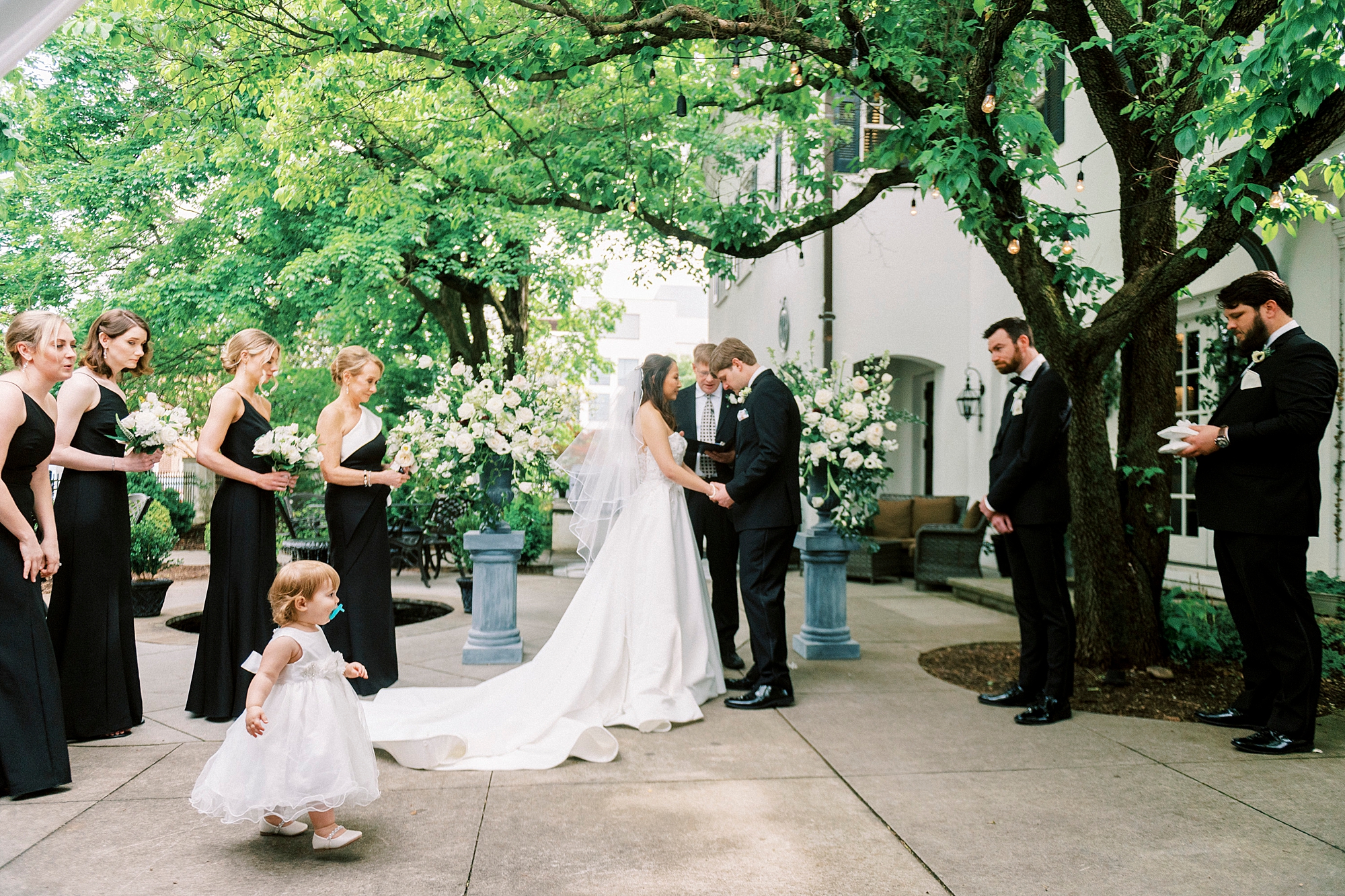 bride and groom lean together holding hands during wedding ceremony 