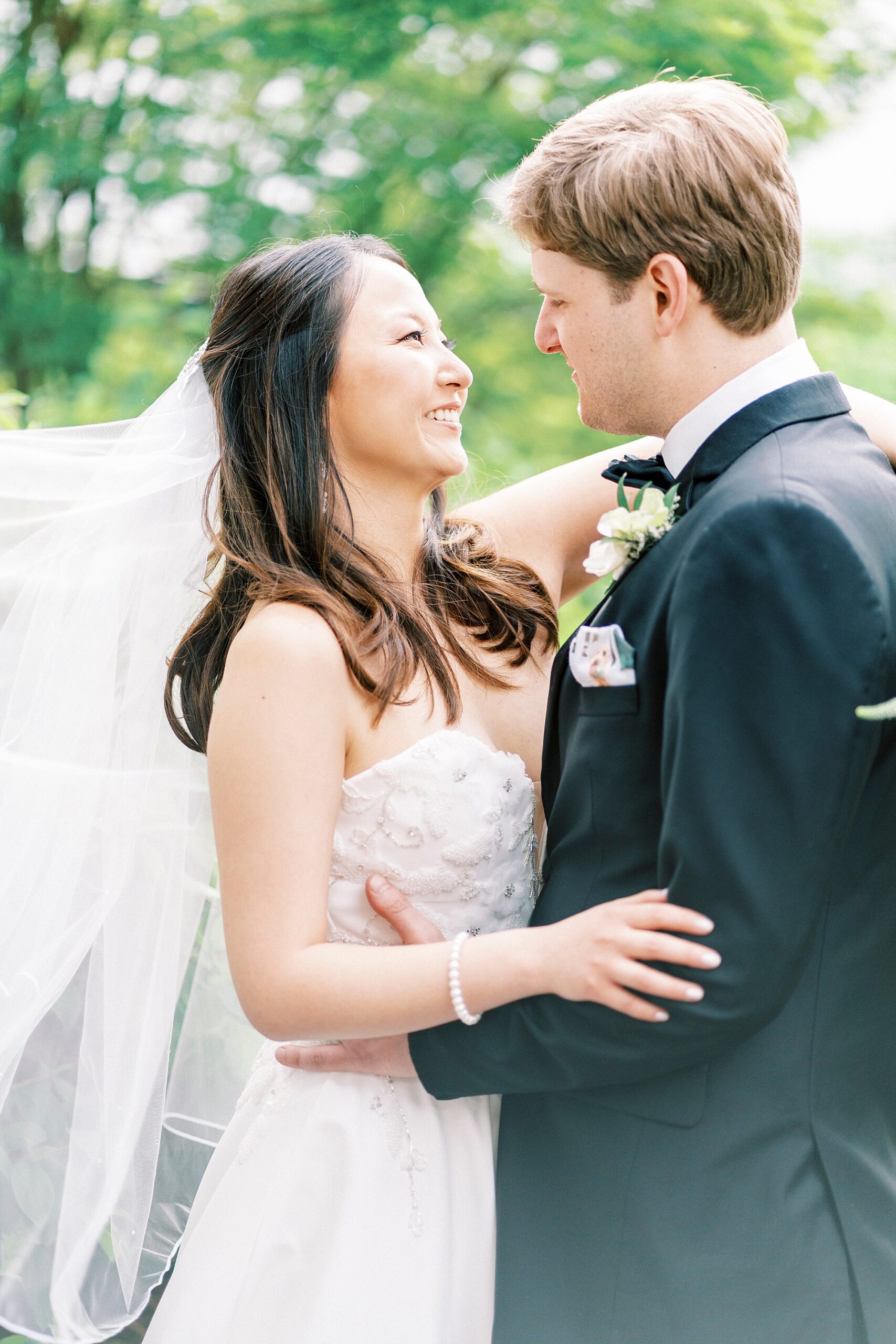 bride and groom hug with bride's veil floating behind them at The Spring House