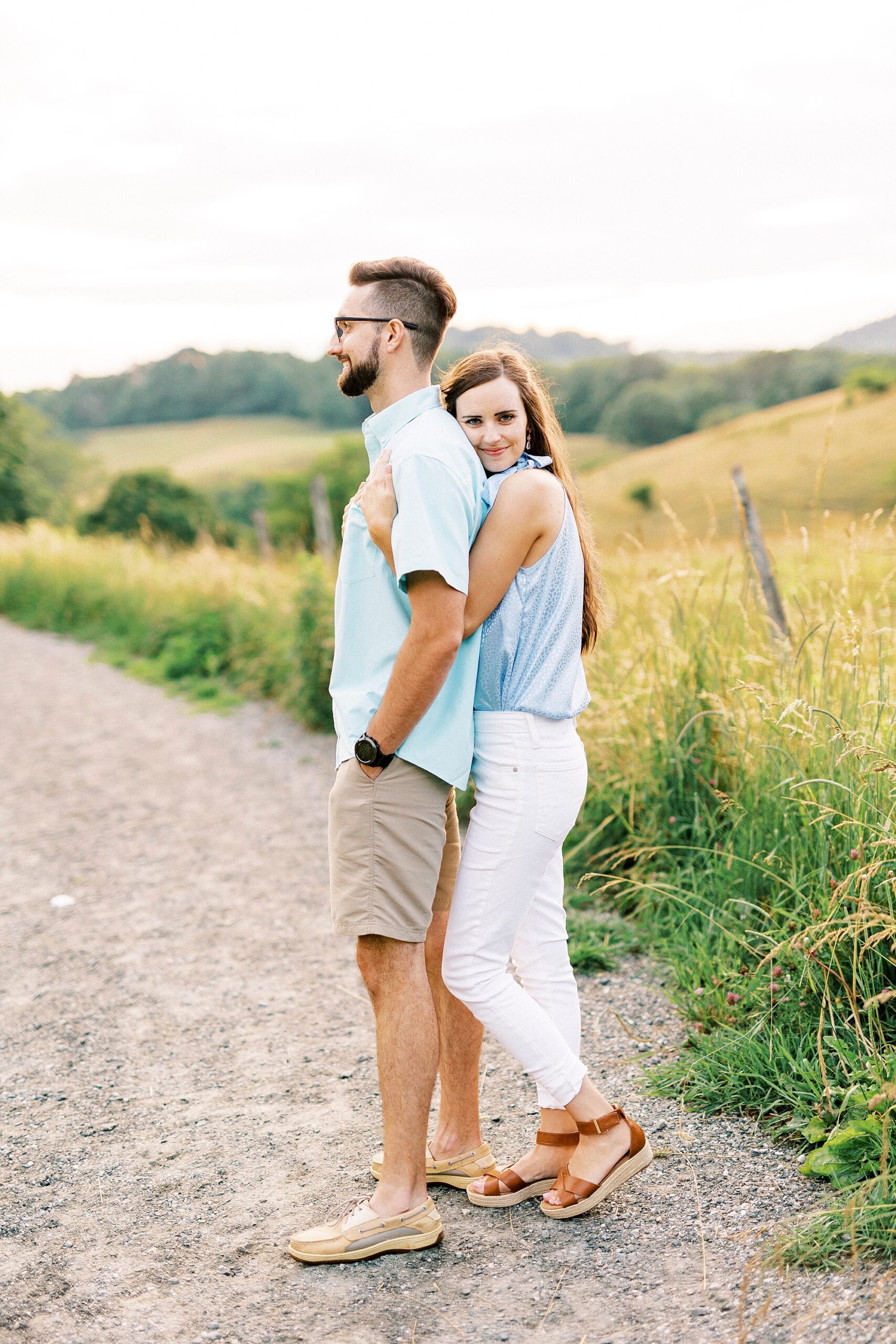 woman hugs man from behind during Blue Ridge Parkway engagement session