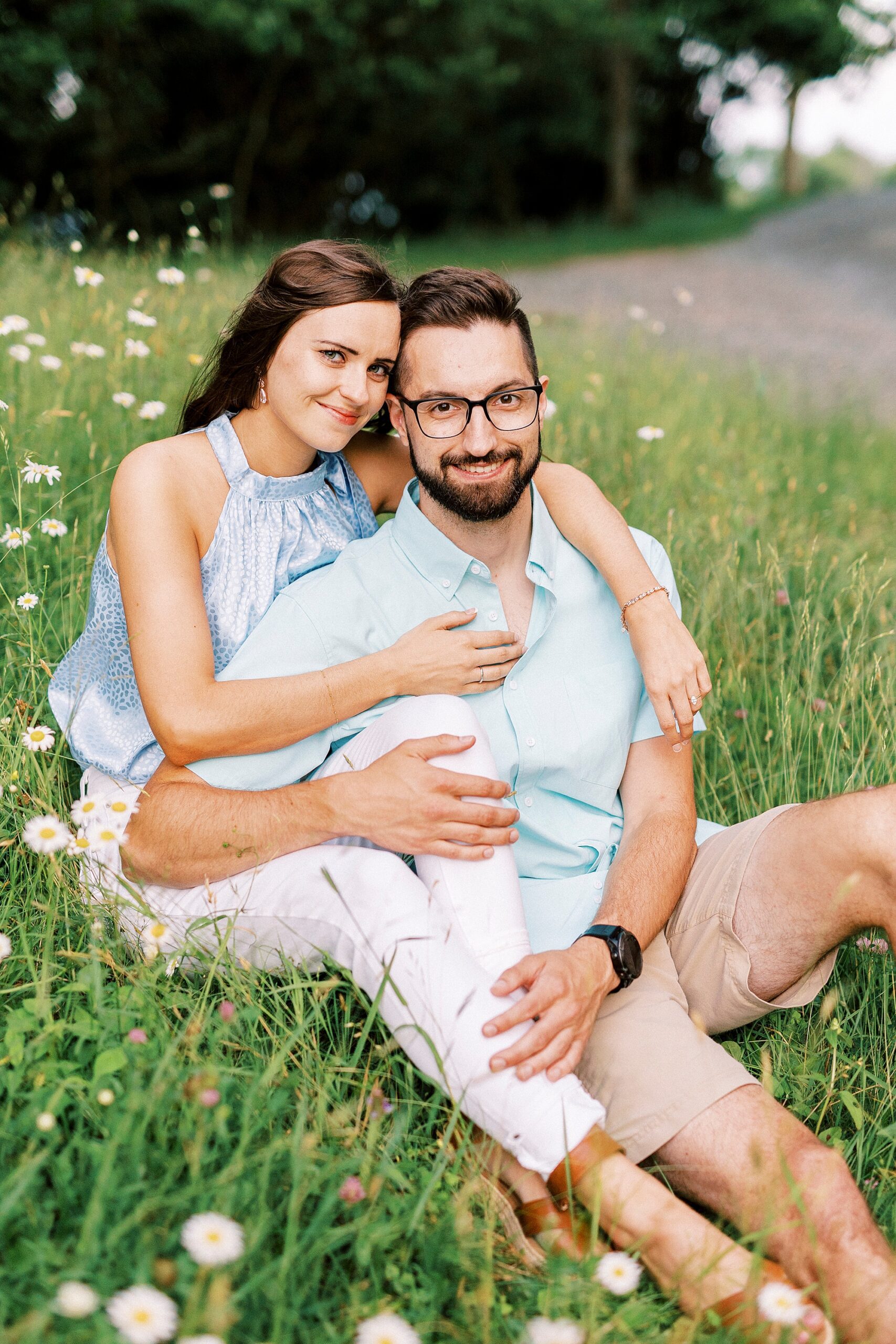 woman hugs man from behind in field near Moses Cone Manor