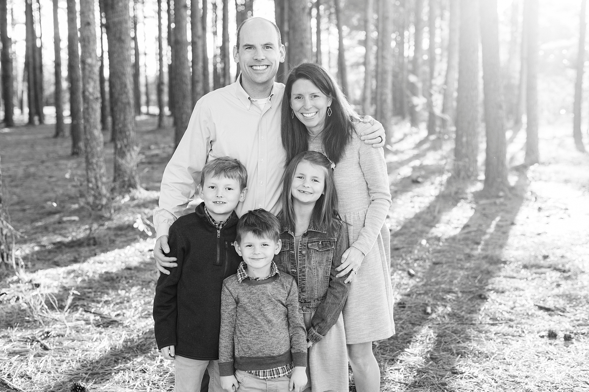parents pose with three kids in woods of Frank Liske Park