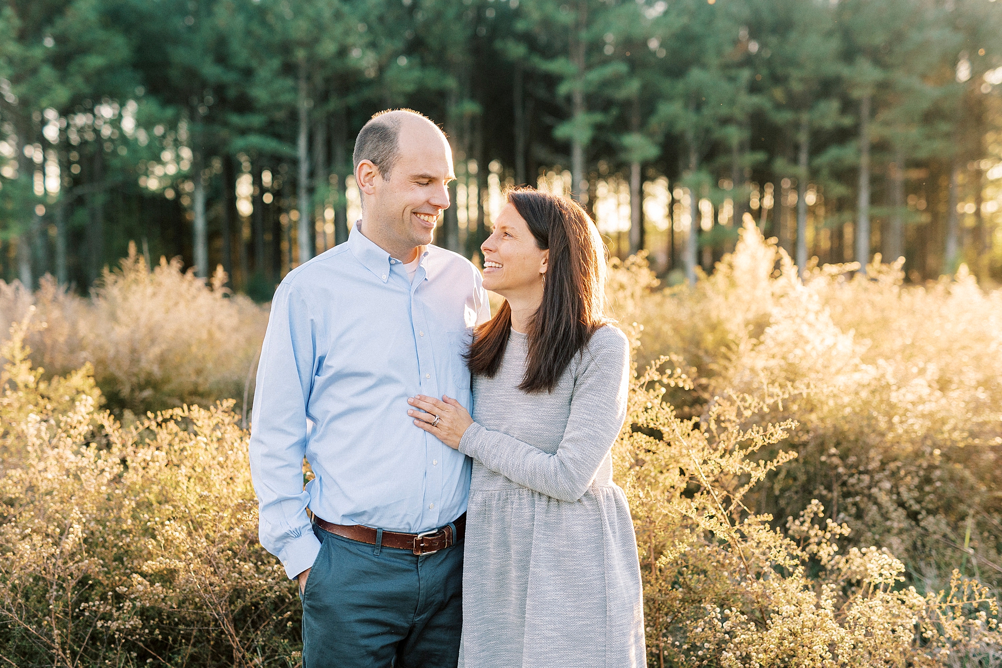 woman in grey dress looks up at husband on edge of field at Frank Liske Park
