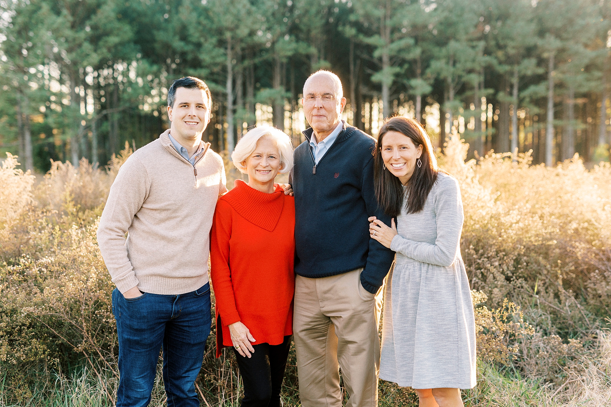 woman holds onto father's arm while her husband stands with her mom