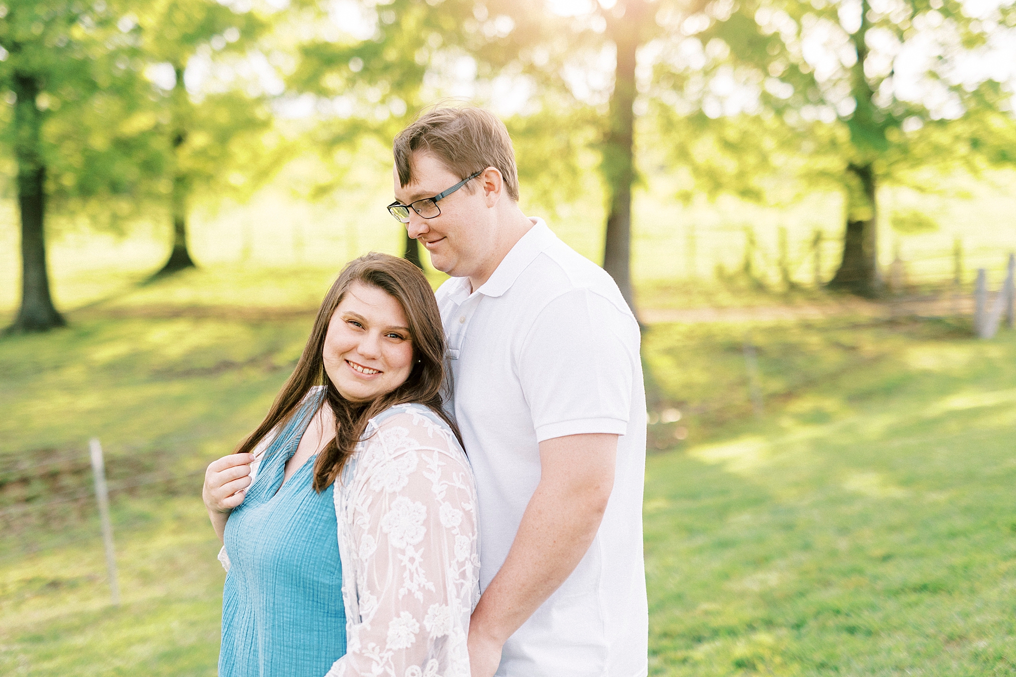 engaged couple hugs standing on lawn at the Farmstead