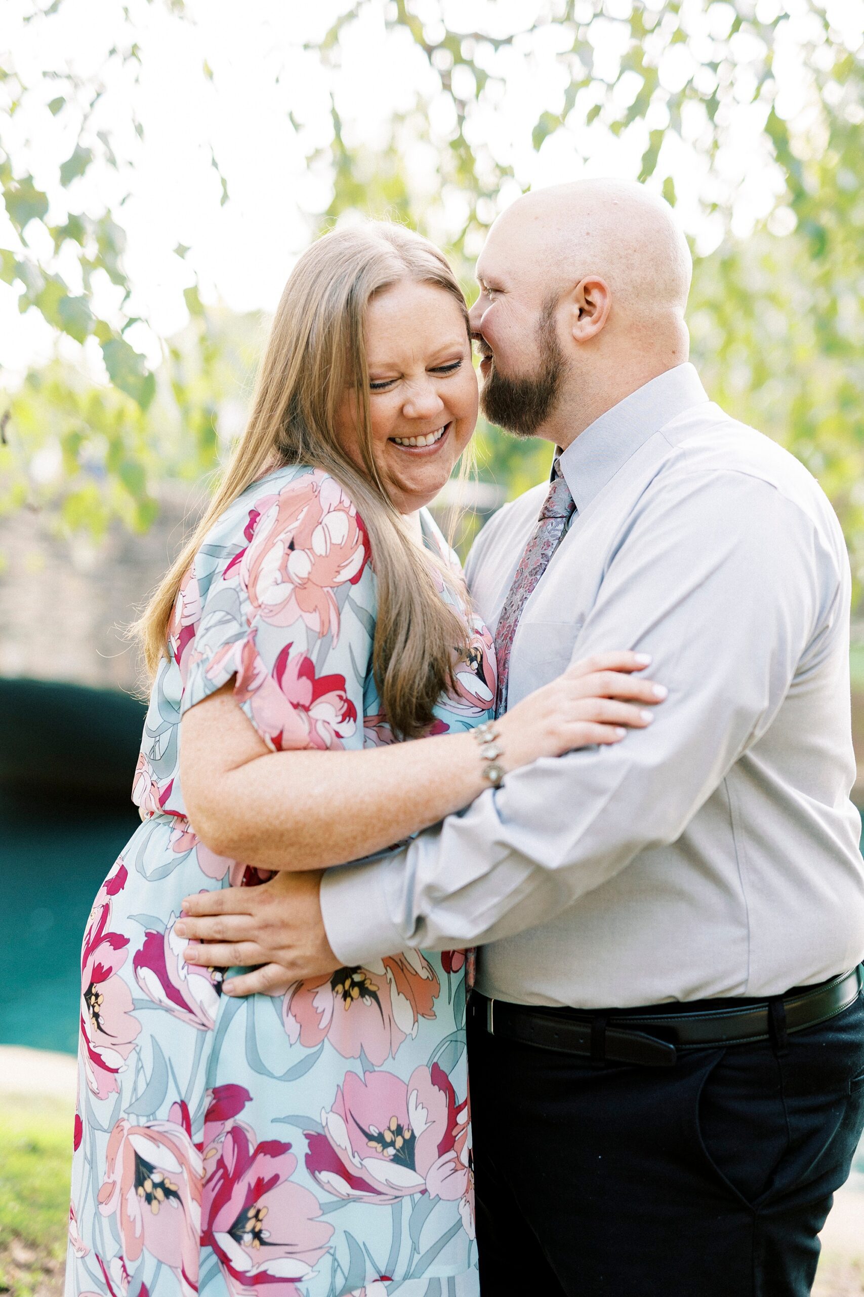 man kisses woman's cheek during Freedom Park engagement portraits