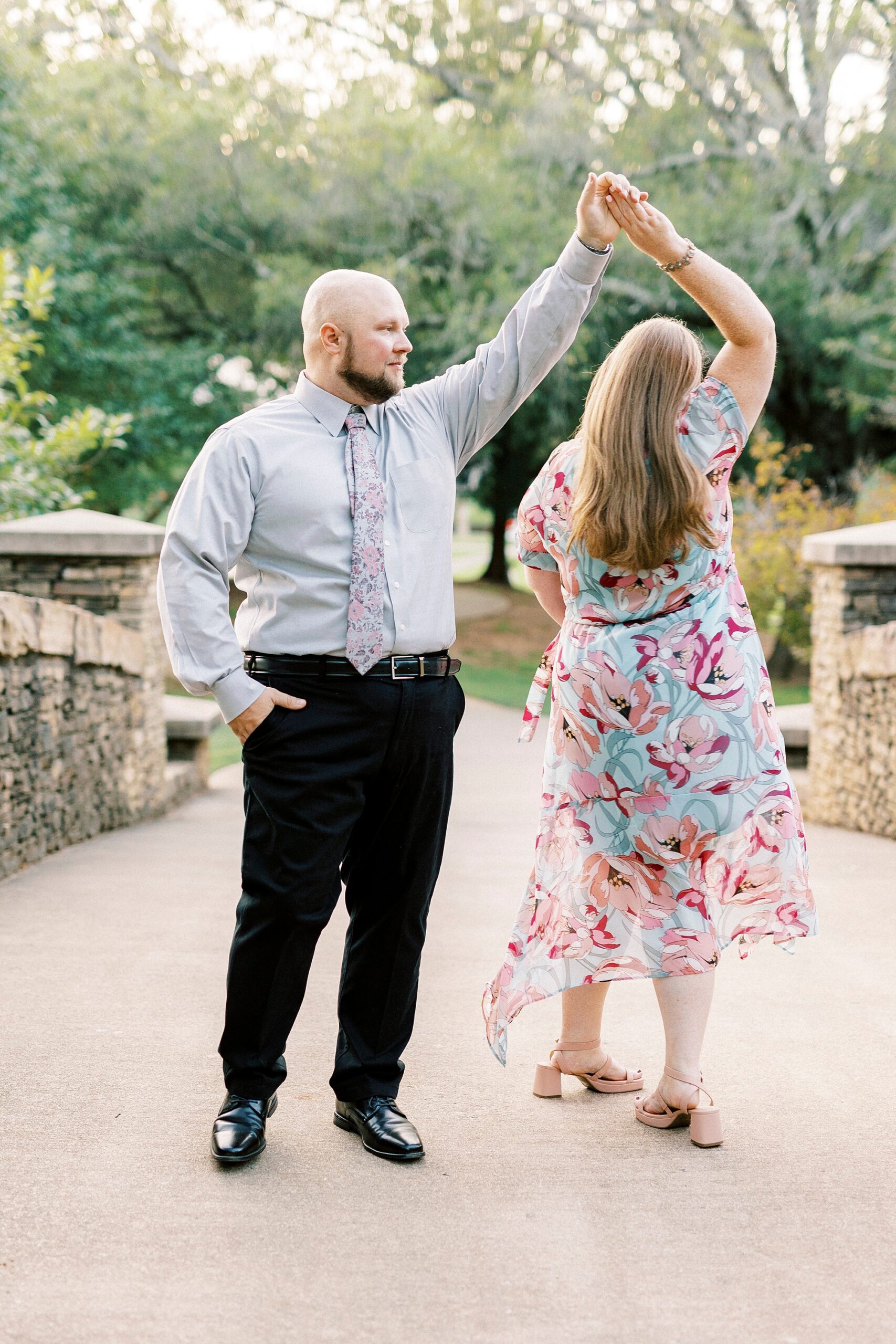 man twirls woman during Freedom Park engagement portraits