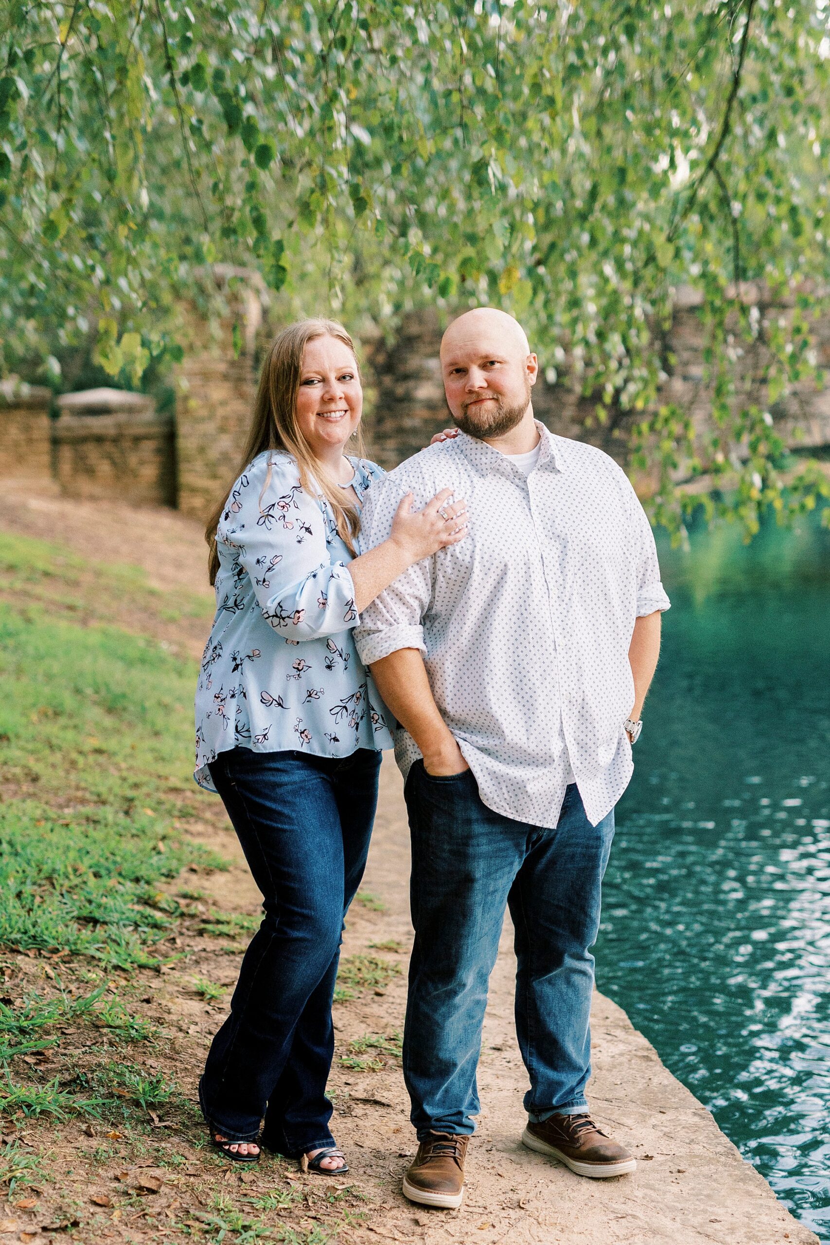woman stands behind man near pond in Freedom Park