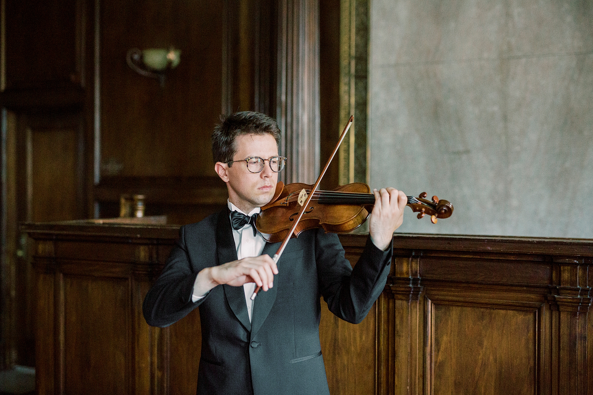 violin player in tux plays violin in manor during headshots