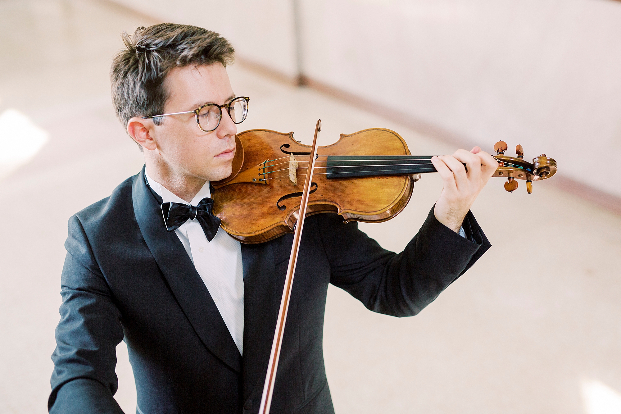 man plays violin in manor home in South Carolina