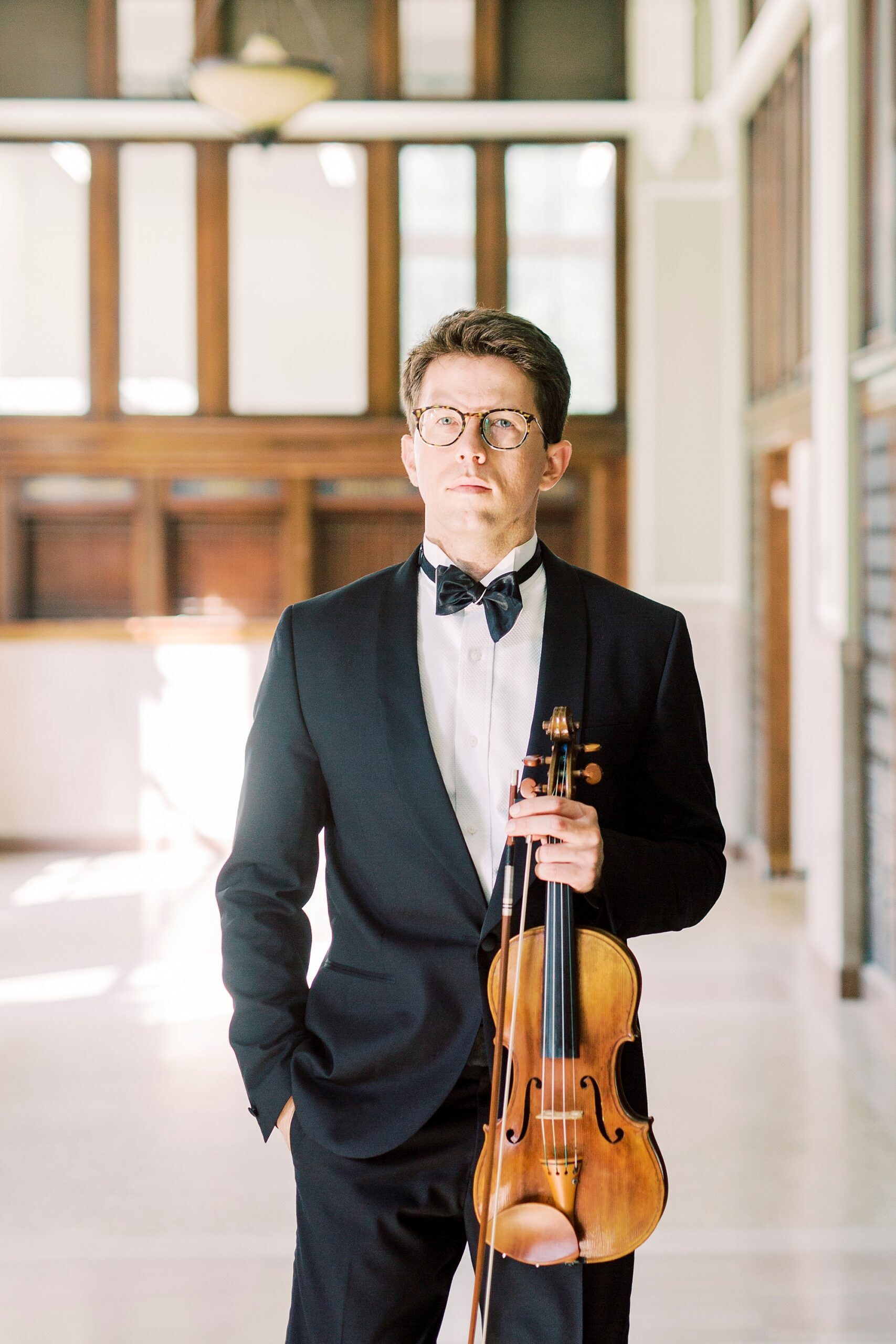 violin player in tux stands holding violin in SC home