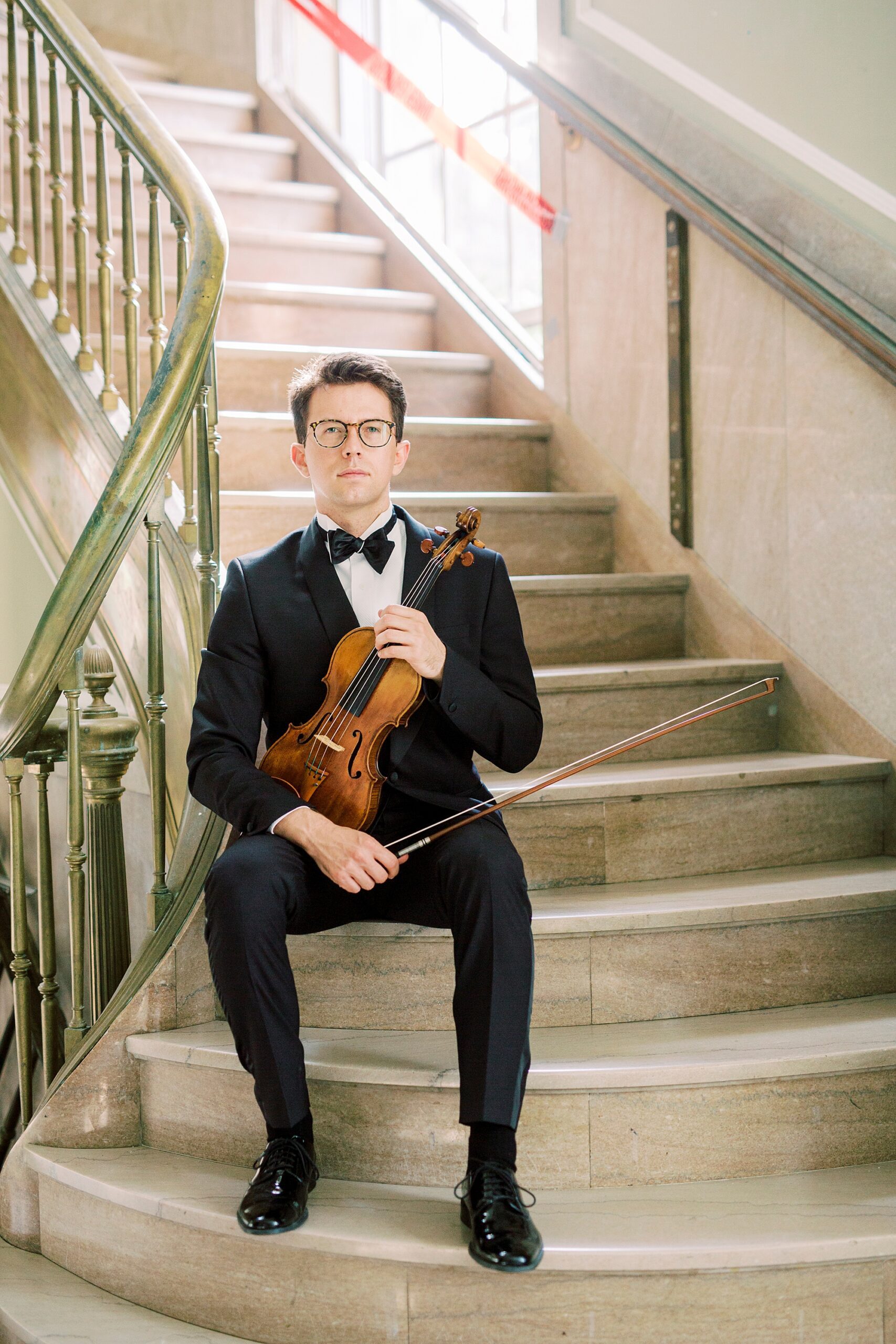 violin player sits on steps during headshots in Rock Hill SC