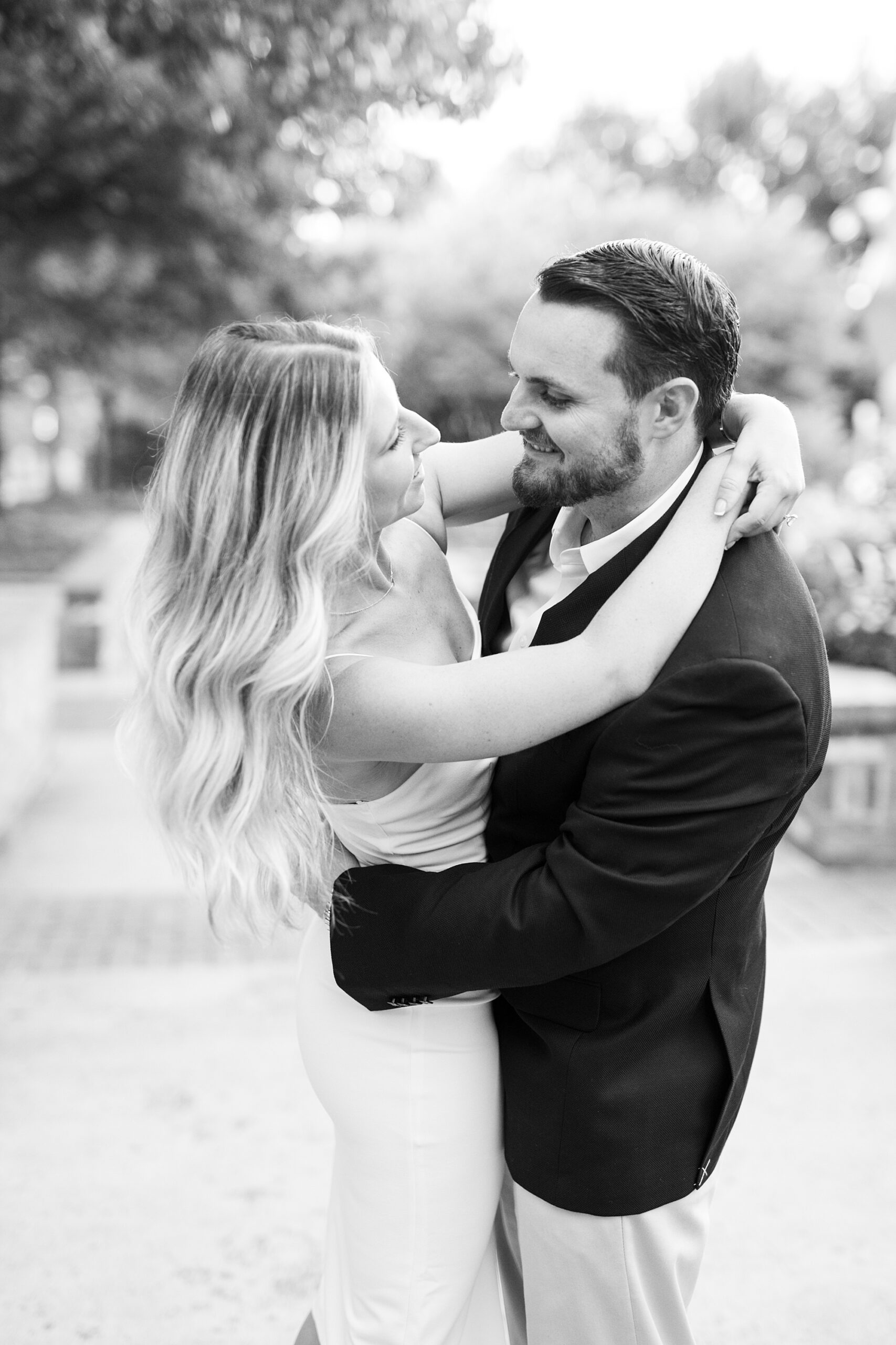 man hugs woman inside Romare Bearden Park twirling with her