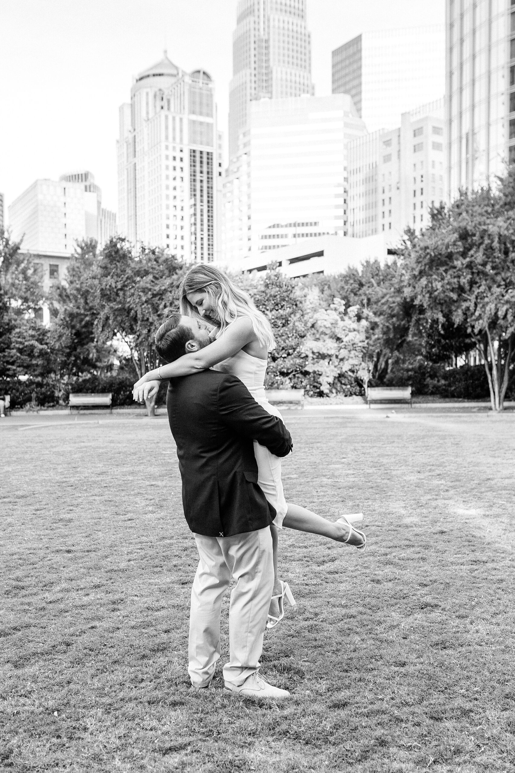 man lifts up fiancee twirling her in Romare Bearden Park