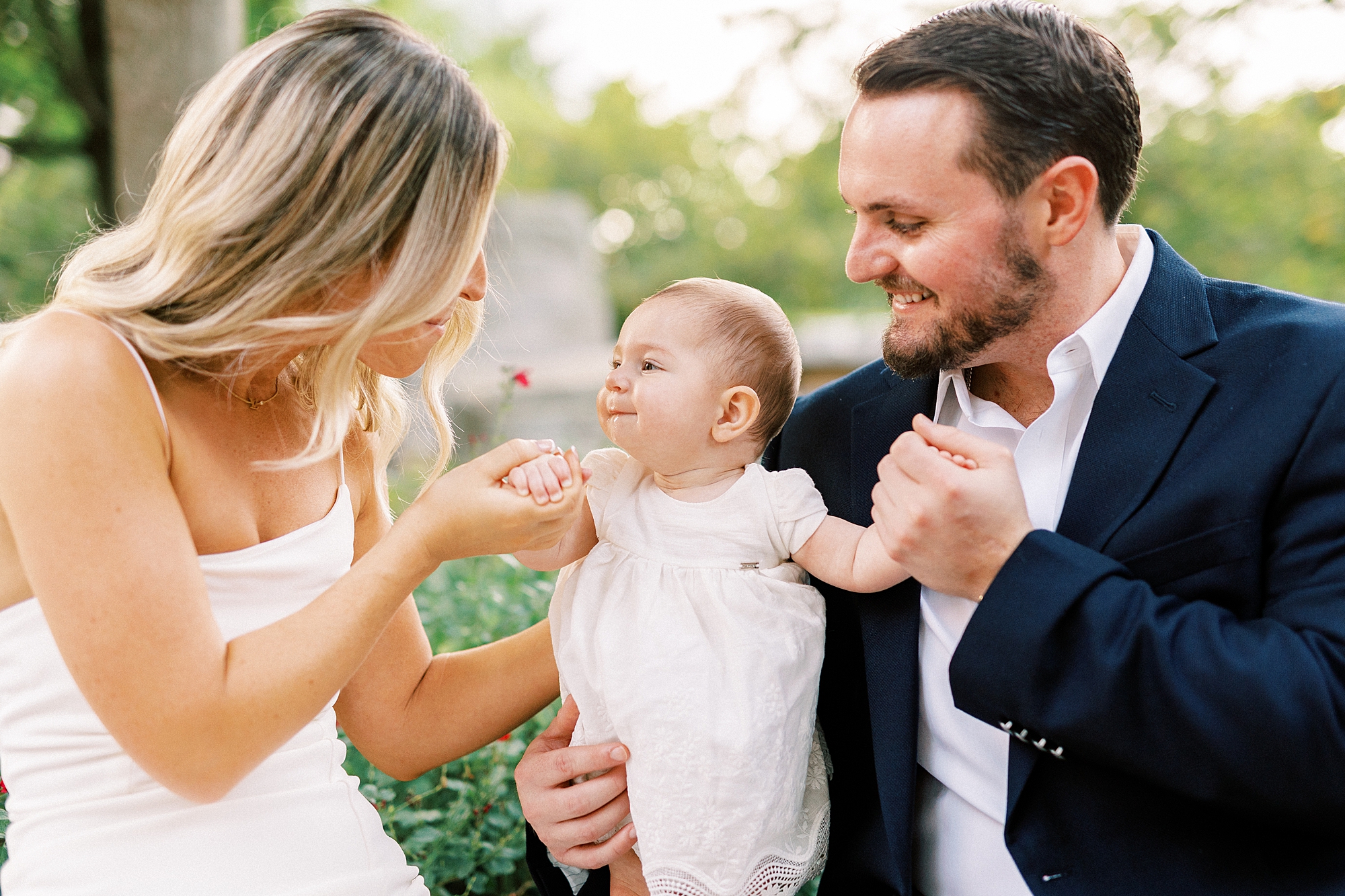 parents look at daughter in Romare Bearden Park during engagement photos