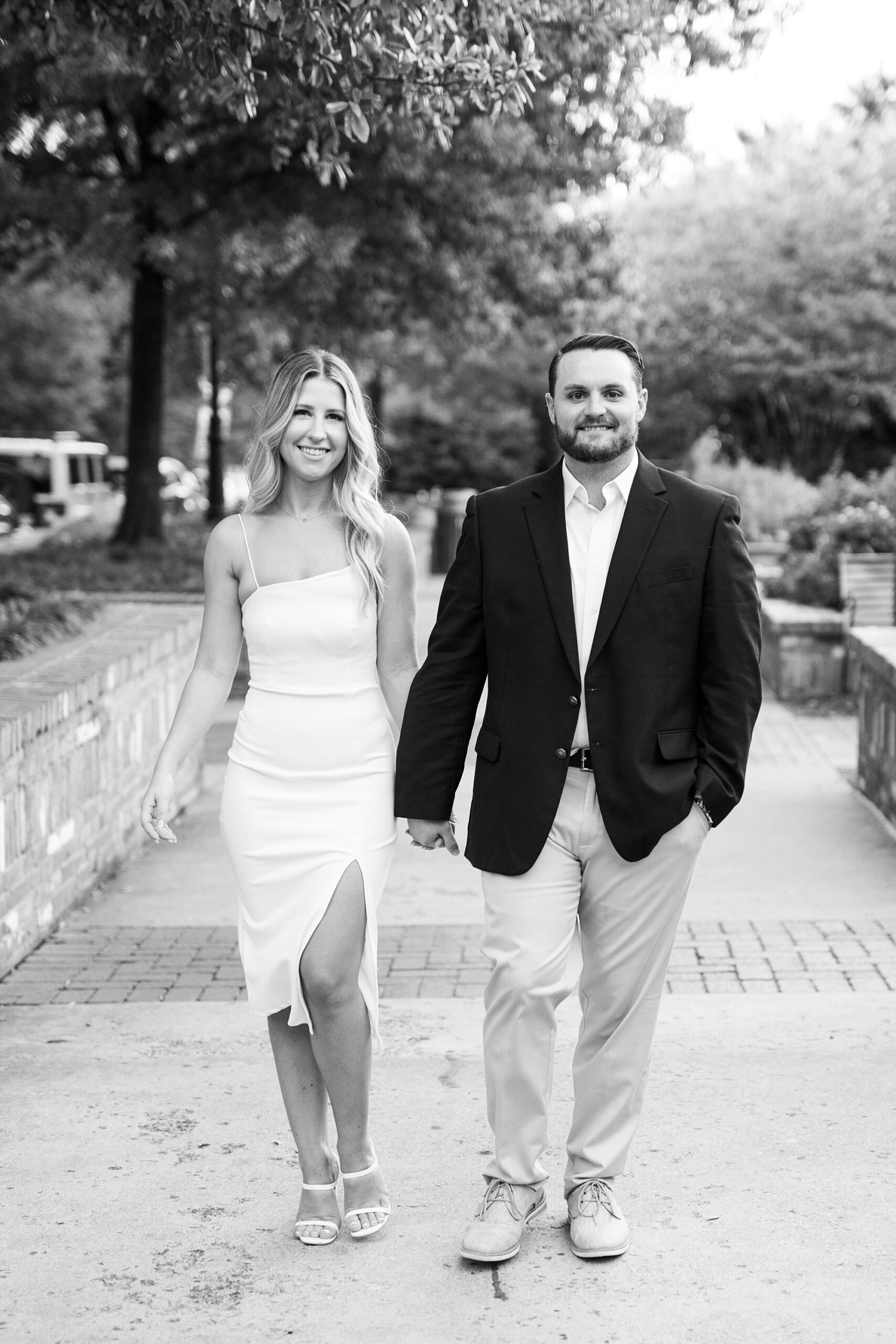engaged couple holds hands walking through Romare Bearden Park