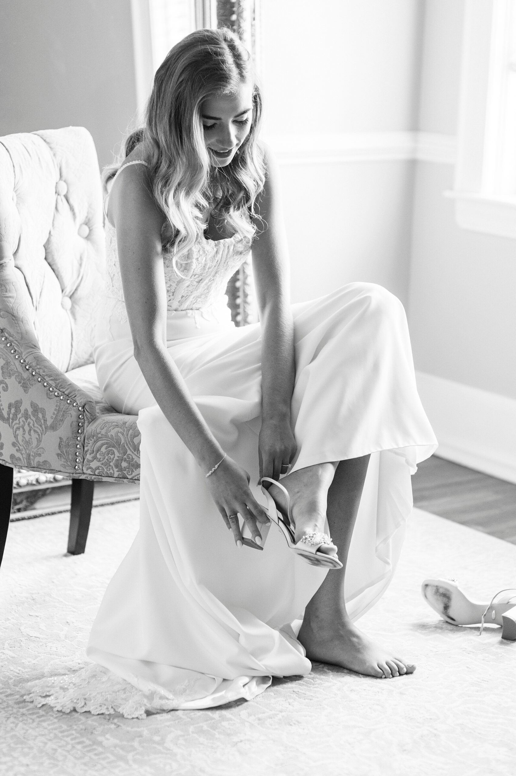 bride puts on shows in chair by window in suite at Separk Mansion