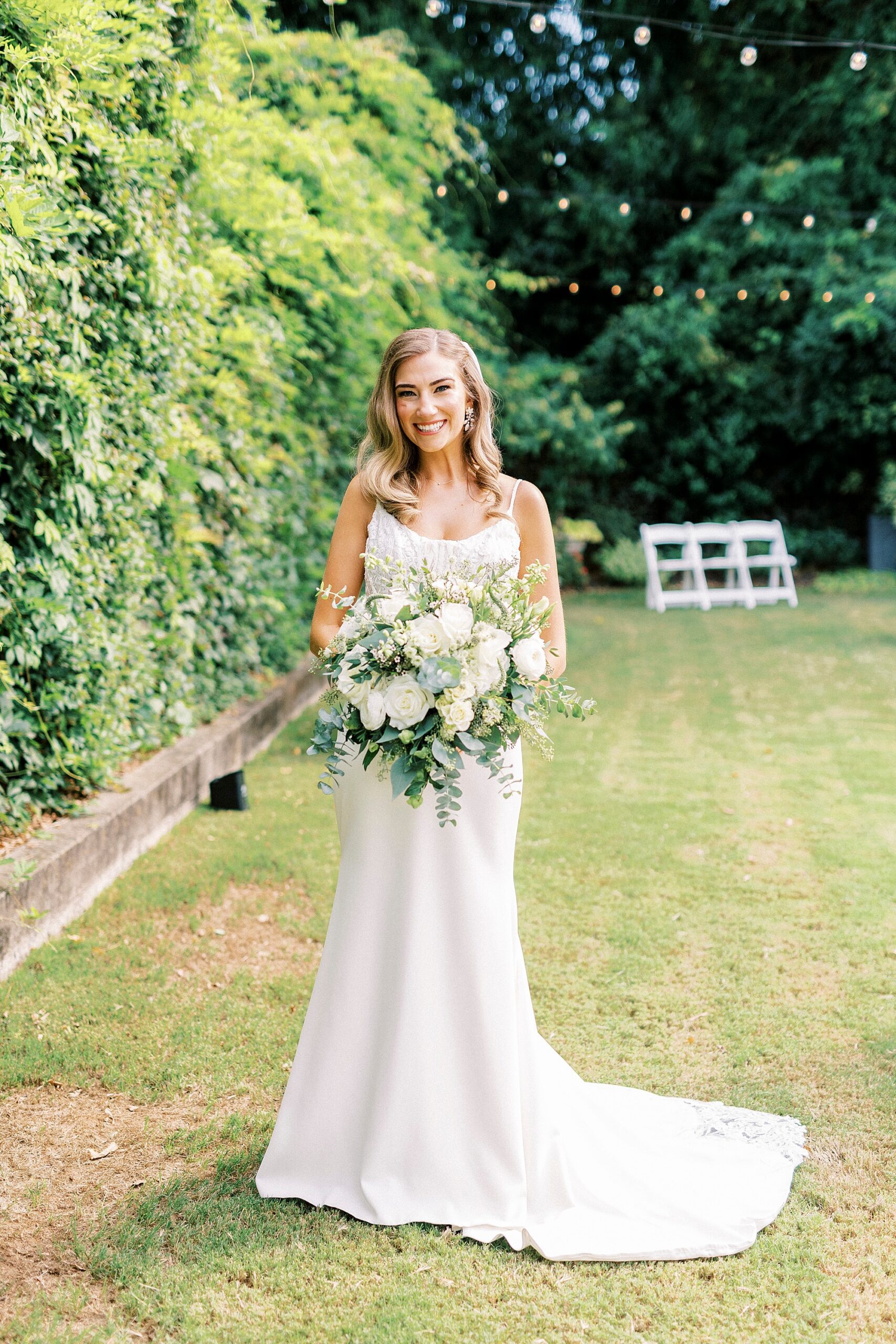 bride stands with skirt of dress around her on lawn at Separk Mansion