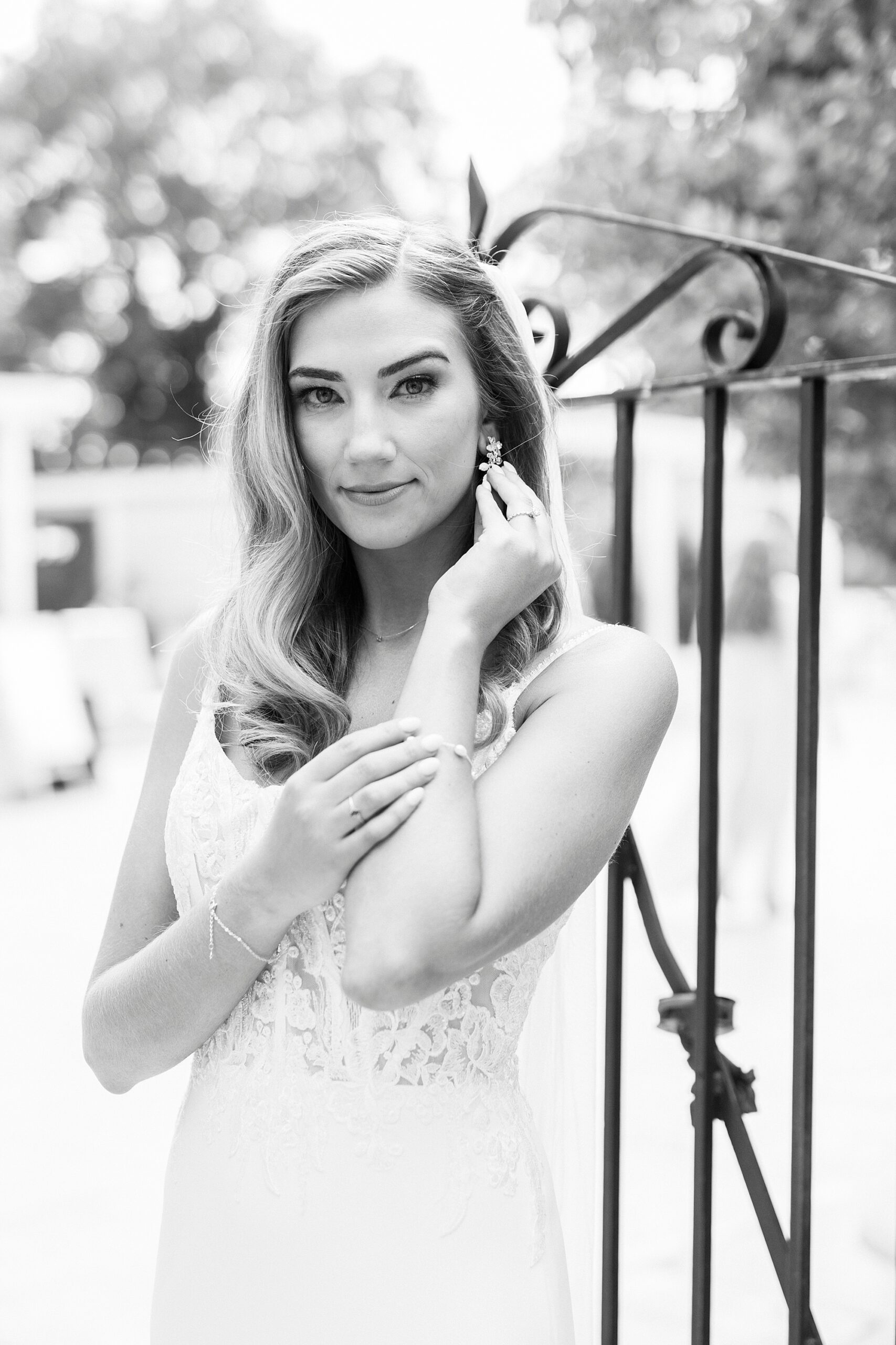 bride pushes hair over ear standing by wrought iron fence at Separk Mansion