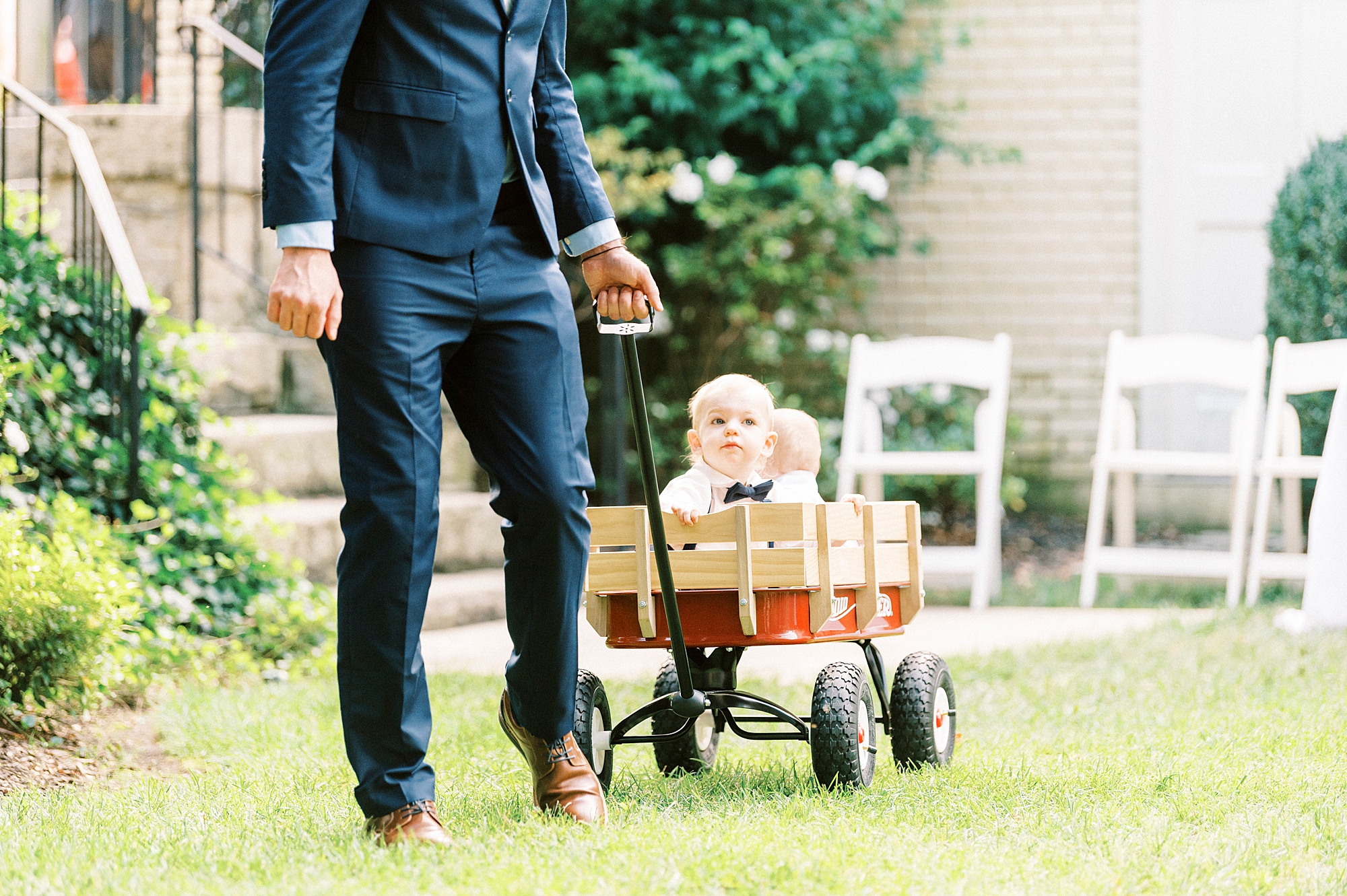 groomsman wheels ring bearer down aisle in red wagon at Separk Mansion