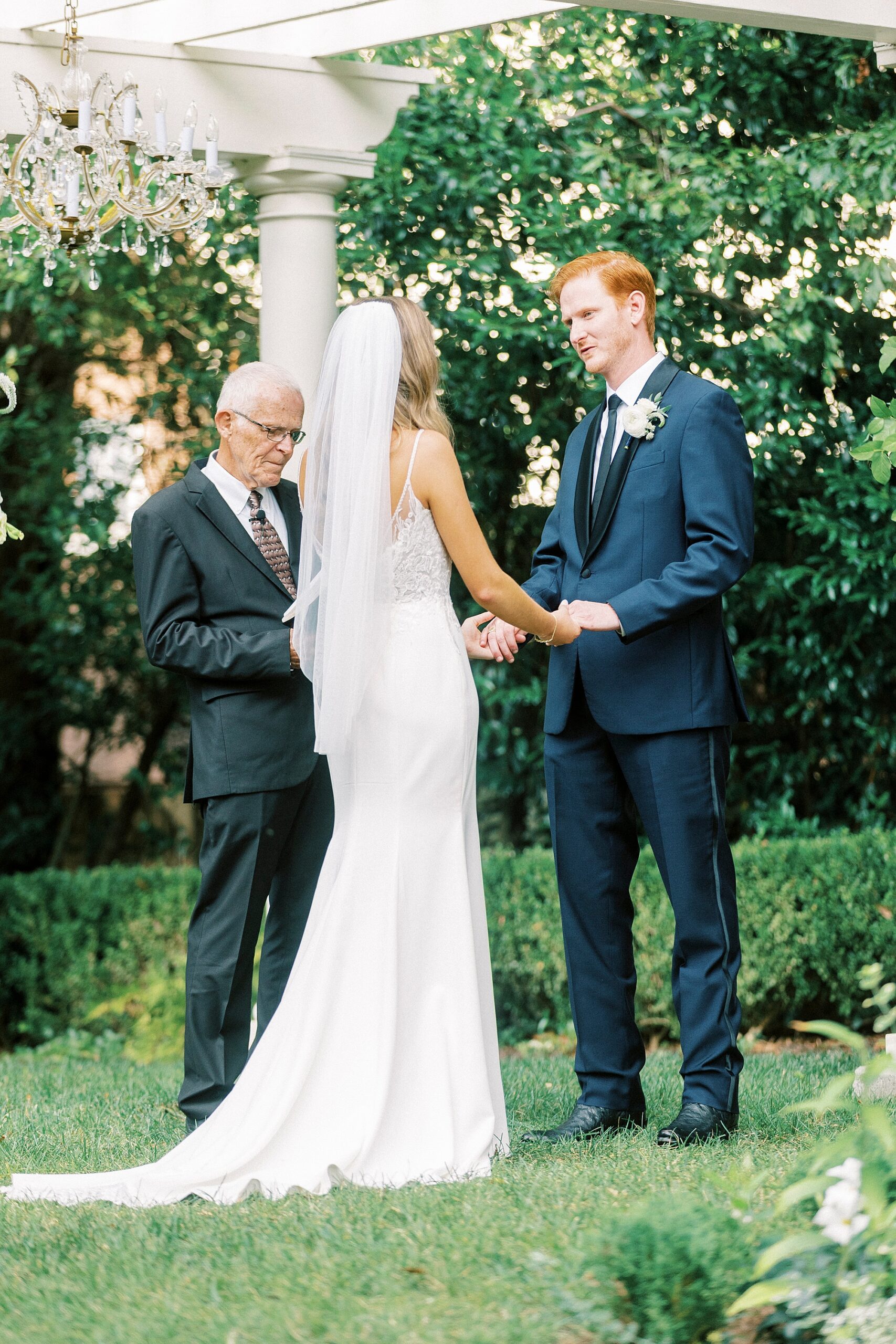 bride and groom hold hands during wedding ceremony at Separk Mansion