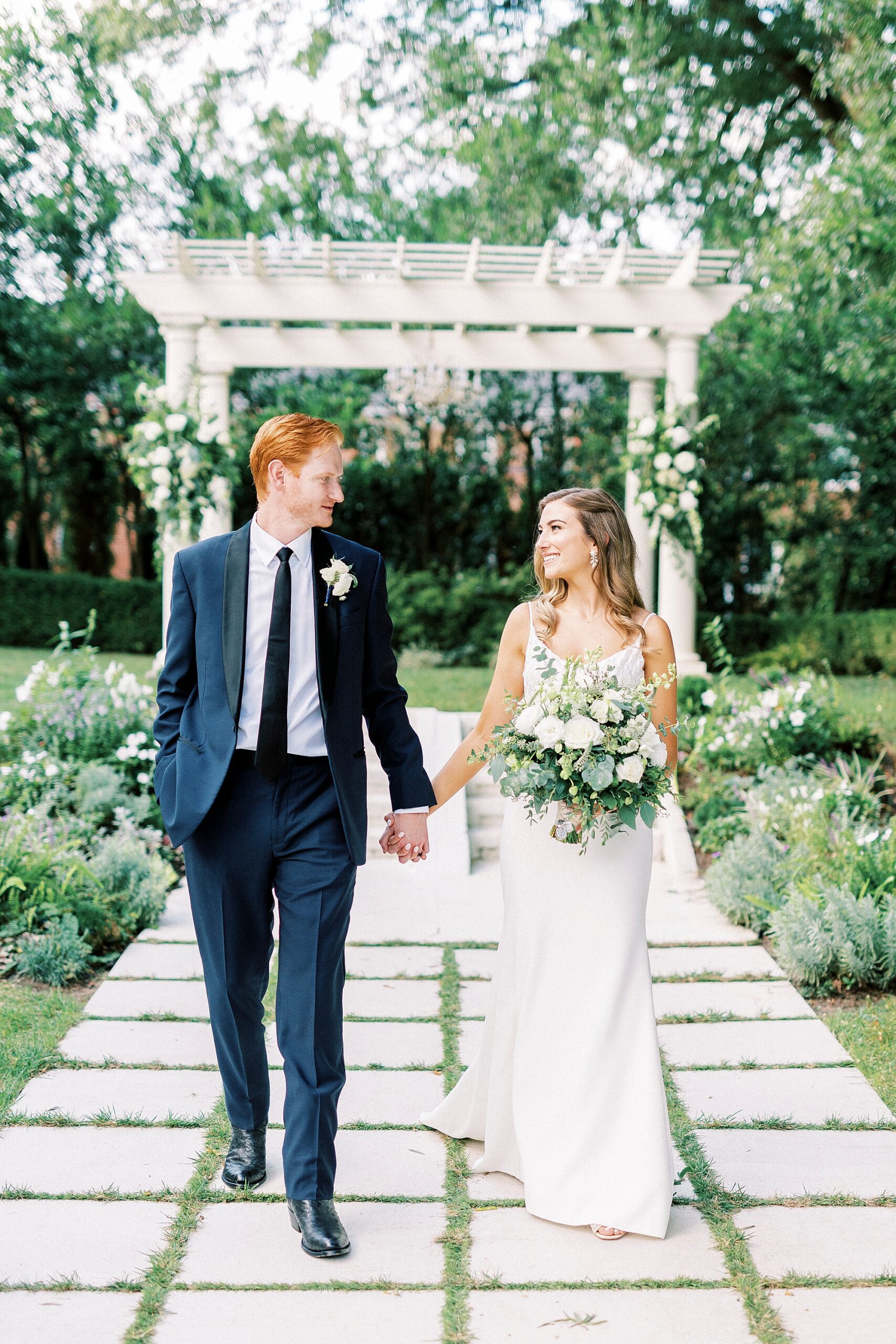 bride and groom hold hands walking away from arbor at Separk Mansion