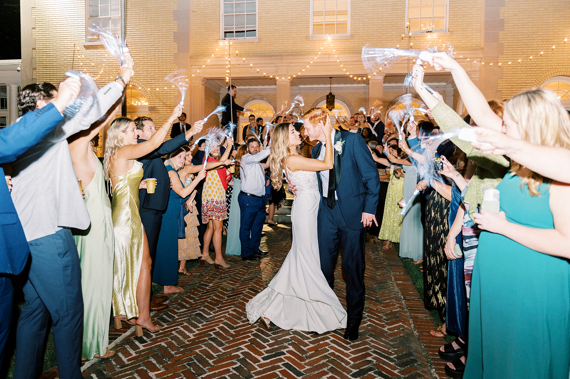 bride and groom kiss during sparkler exit outside Separk Mansion leaving NC wedding reception