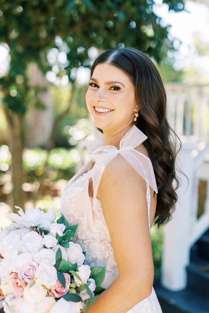 bride smiles over shoulder showing off bow on wedding gown 