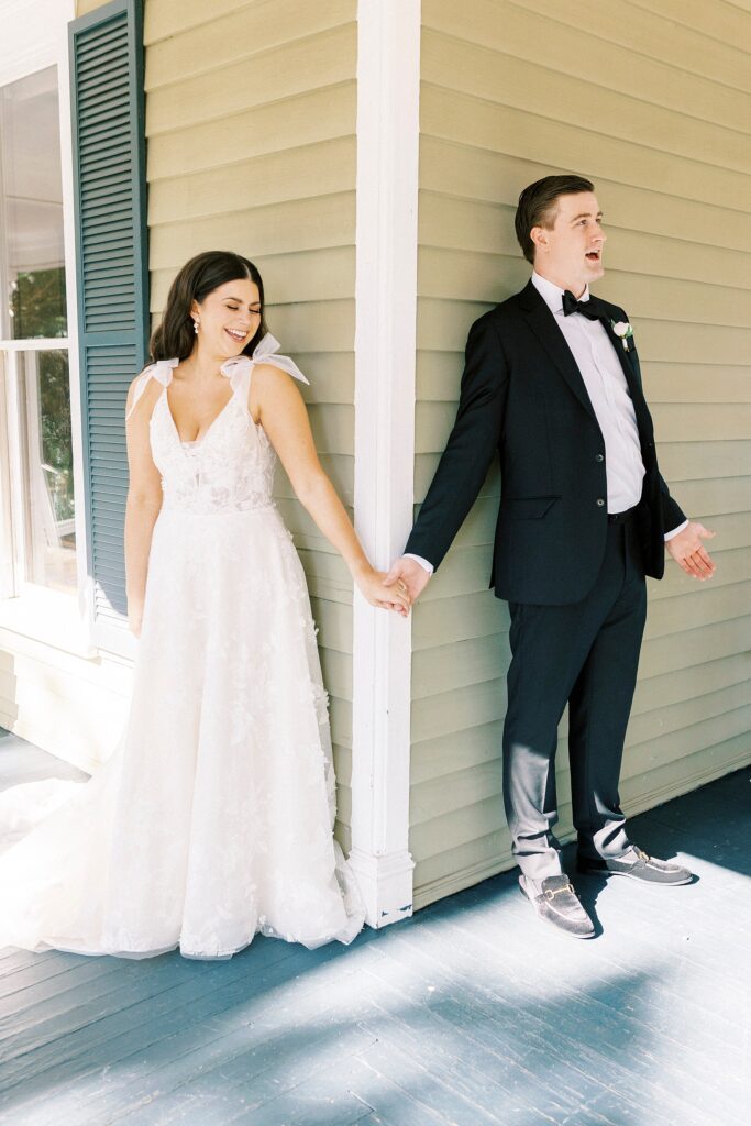 bride and groom have first touch around corner at Whitehead Manor